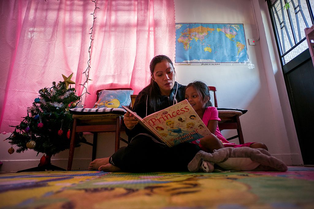 Filipino refugee Vanessa Rodel reads to her 4-year-old daughter.