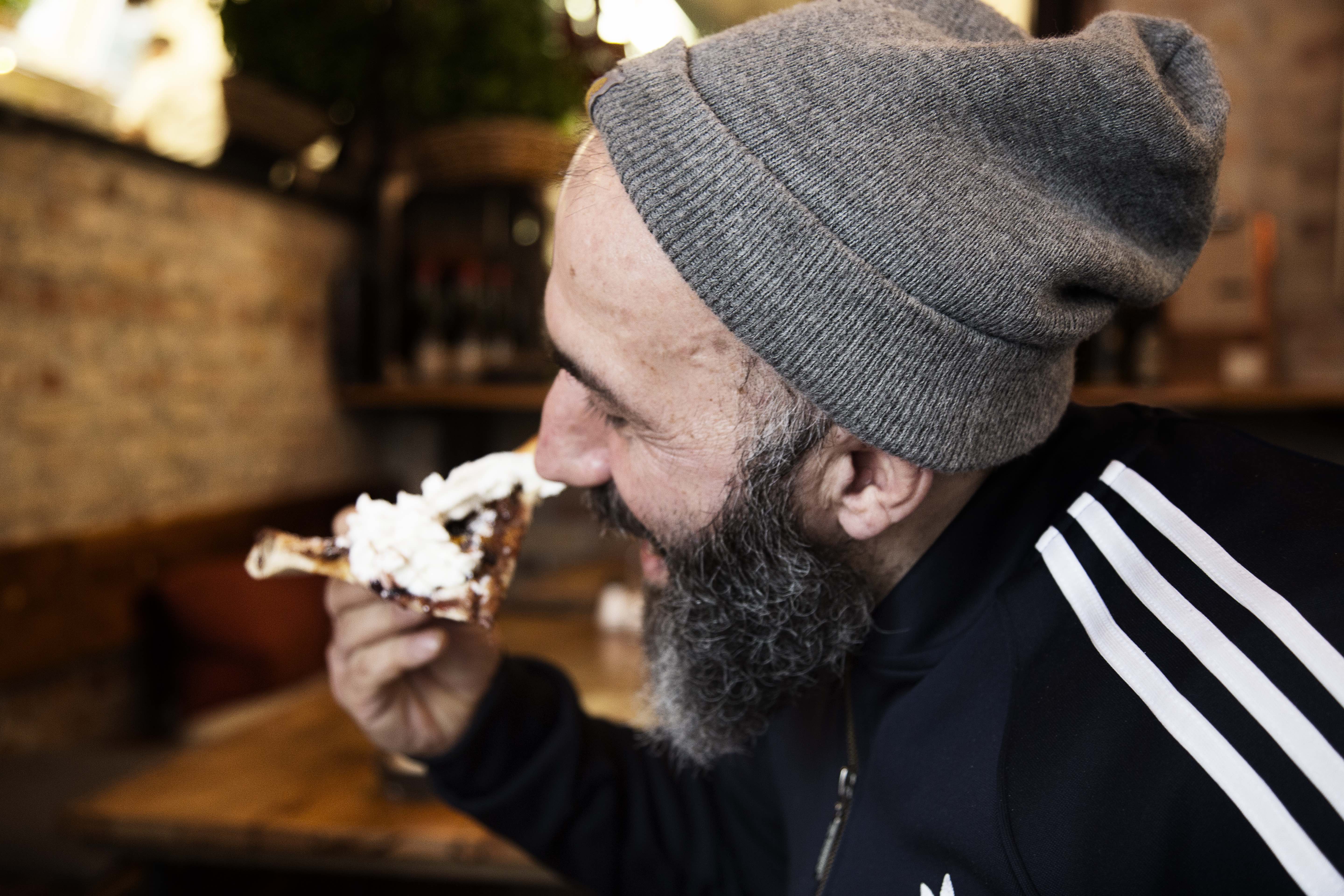 Ibrahim smager på pizzaen med flødeskum.