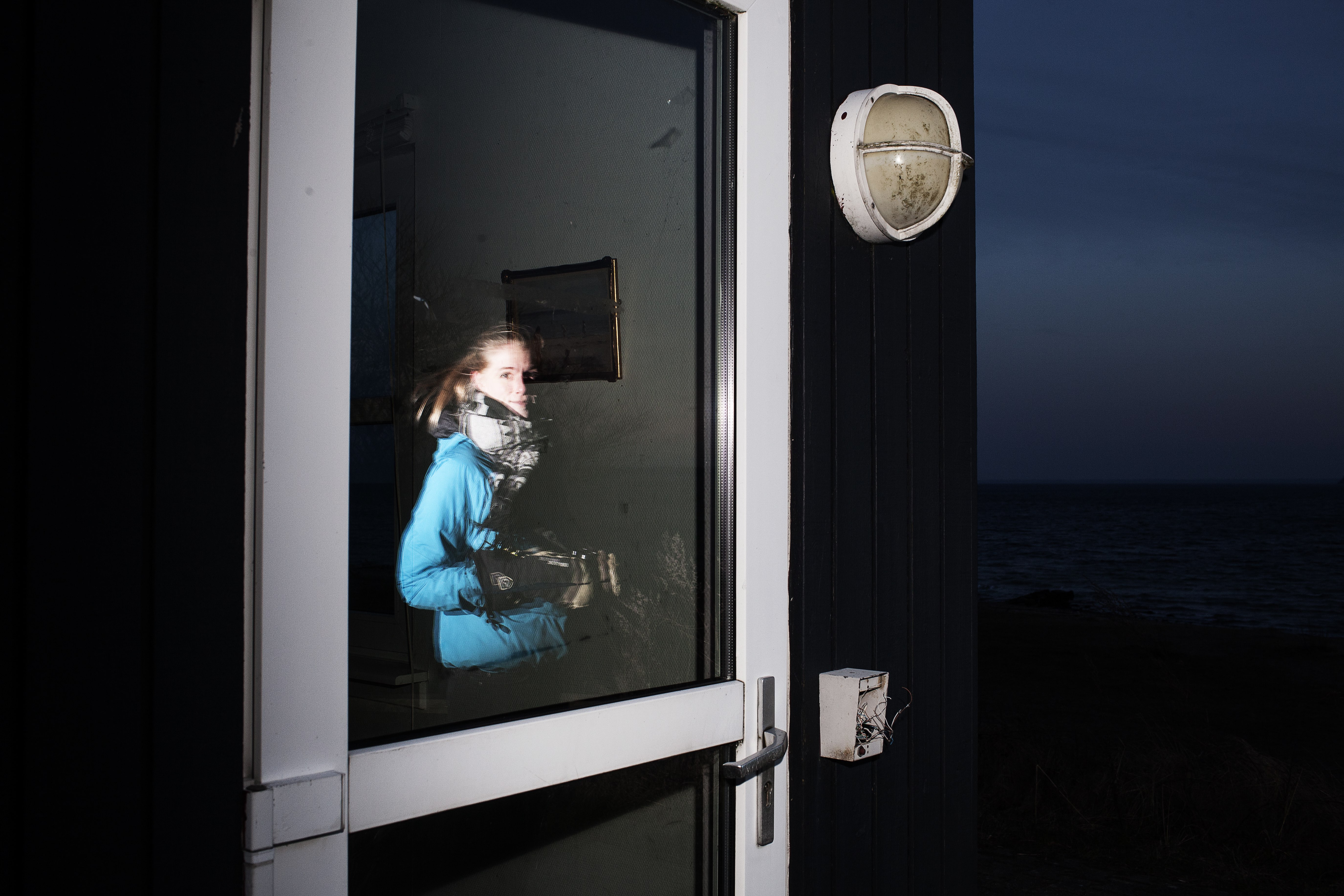 Man ser en dør, og i den kan man se genspejlingen af Sigrid.