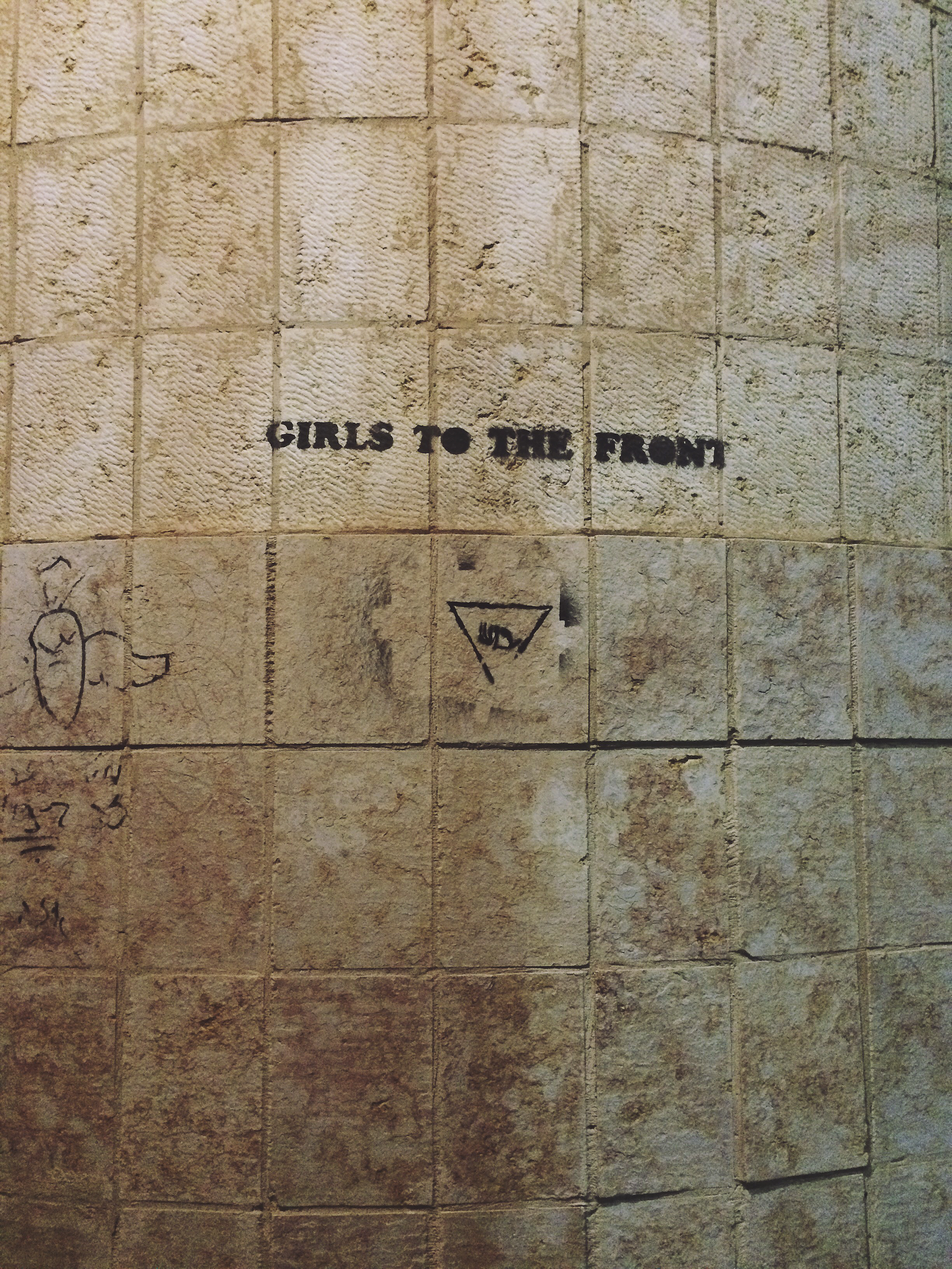 Grafitti på en væg, der står: Girls to the front