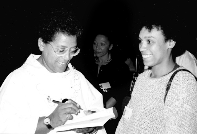 Die Dichterin Audre Lorde signiert auf der International Feminist Book Fair 1988 in Montreal ein Buch, neben ihr lächelt Katharina Oguntoye