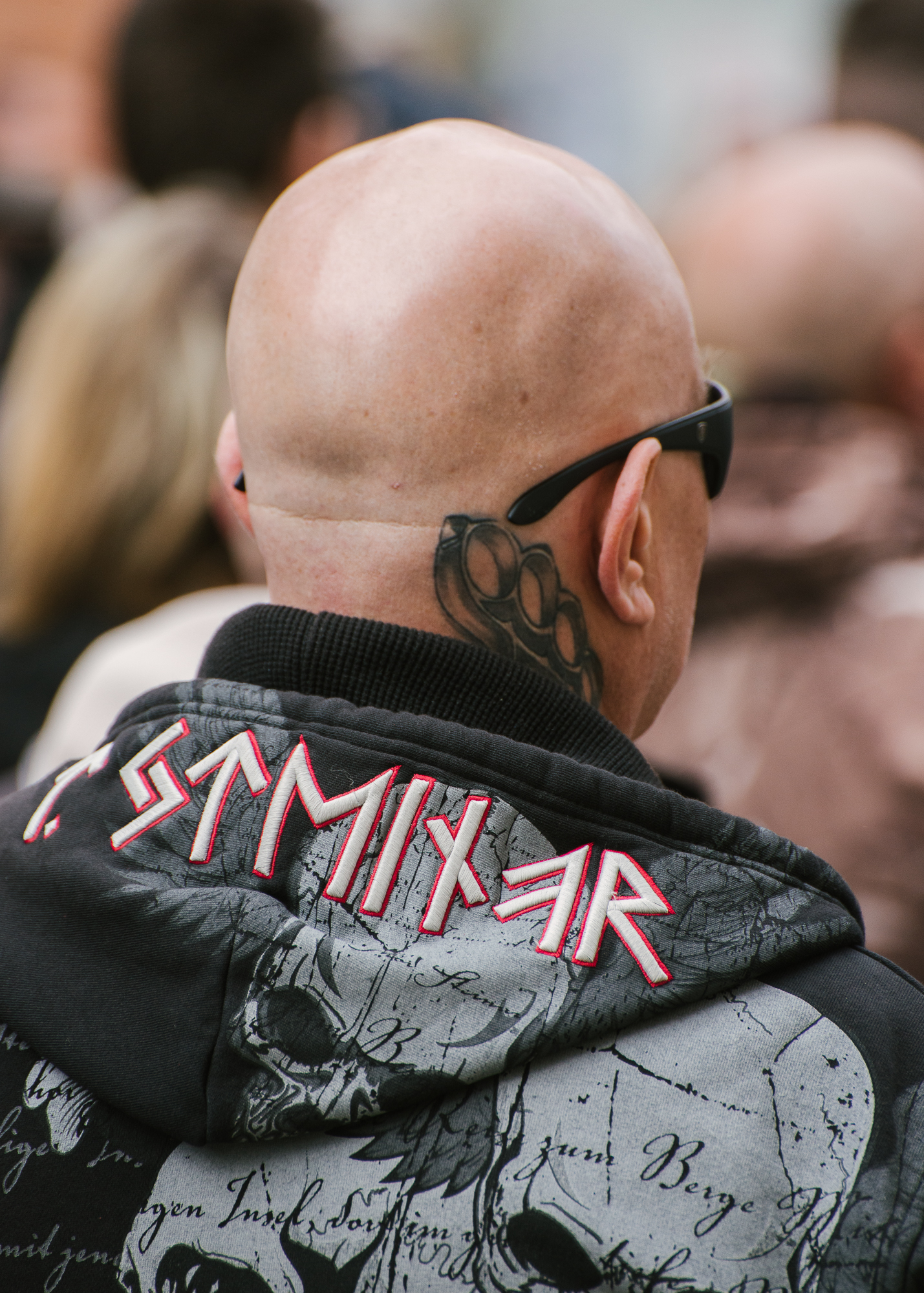 Ein Demoteilnehmer mit Glatze, Sonnenbrille, Faustring-Tattoo und Thor-Steinar-Pulli