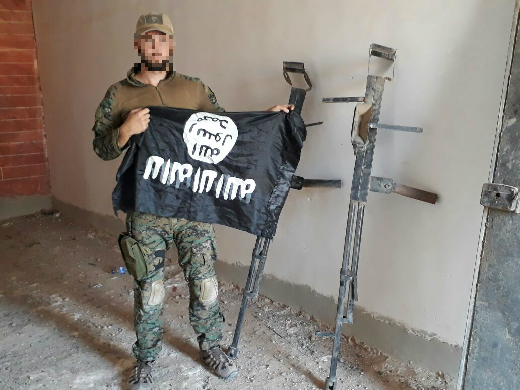 Der deutsche Freiwillige YBS-Milizionär Martin Kamper mit IS-Flagge und Waffenattrappen.