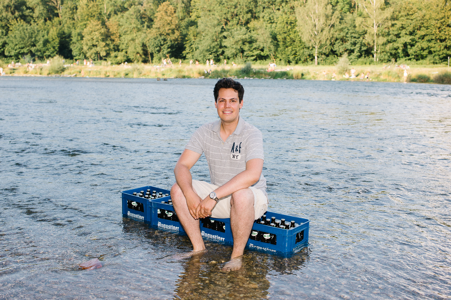 Laurenz Kiefer sitzt auf zwei Bierkisten in der Isar in München