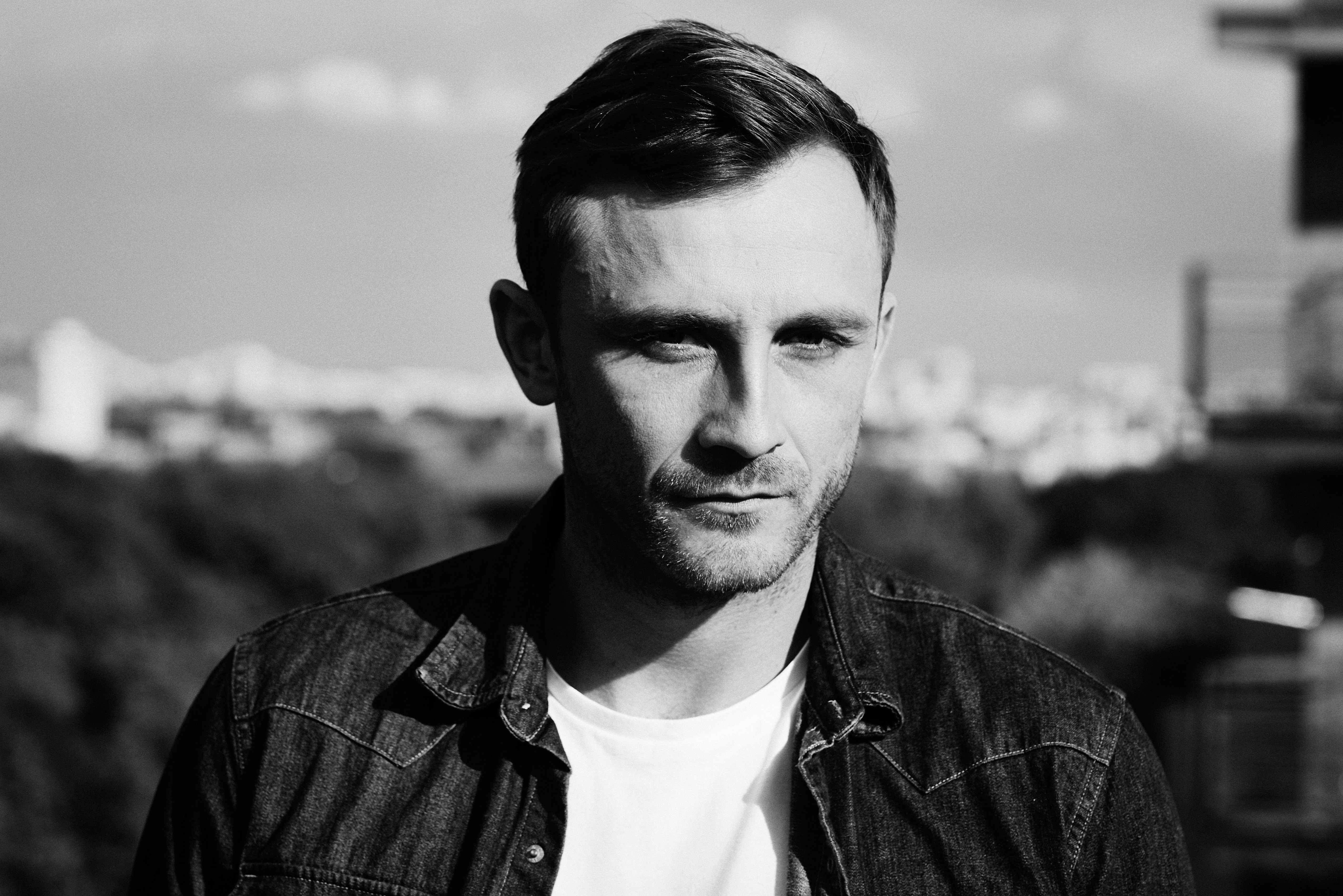 Kamil Nożyński pozuje do zdjęcia na dachu