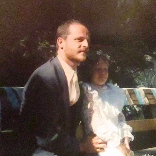 A young girl with a man in a suit.