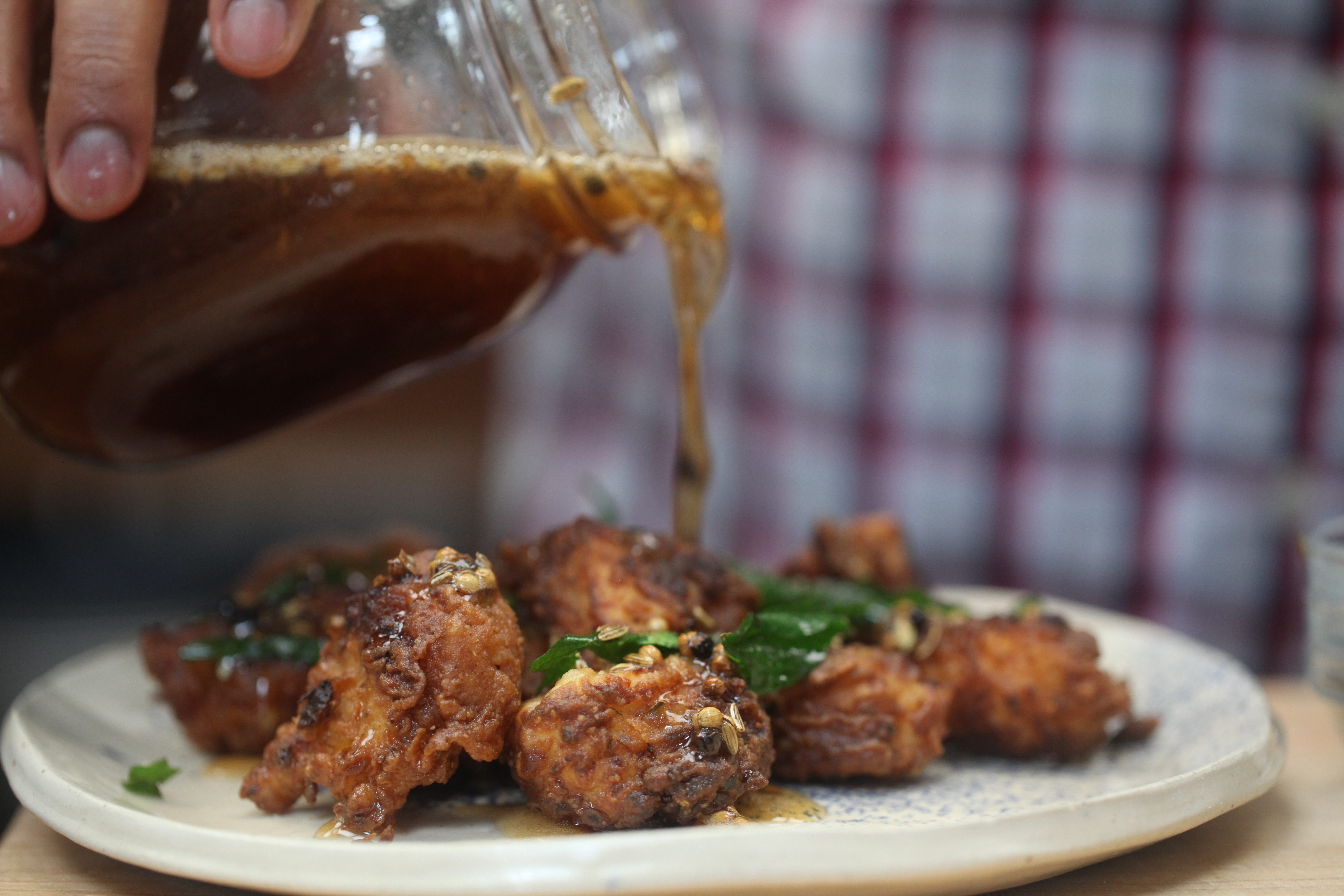 Sauce being drizzled on fried chicken