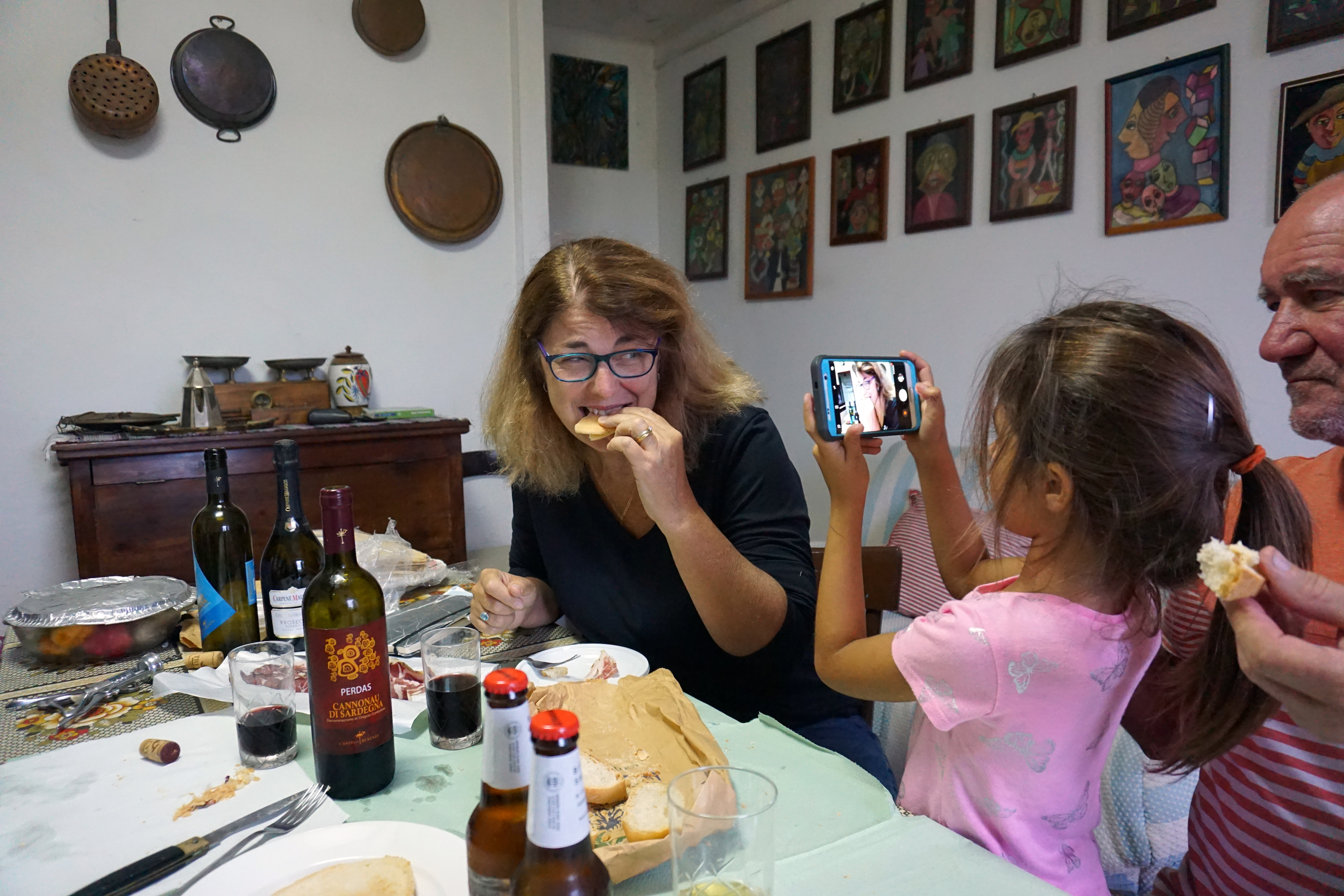 Woman eating cheese while a child takes her picture.