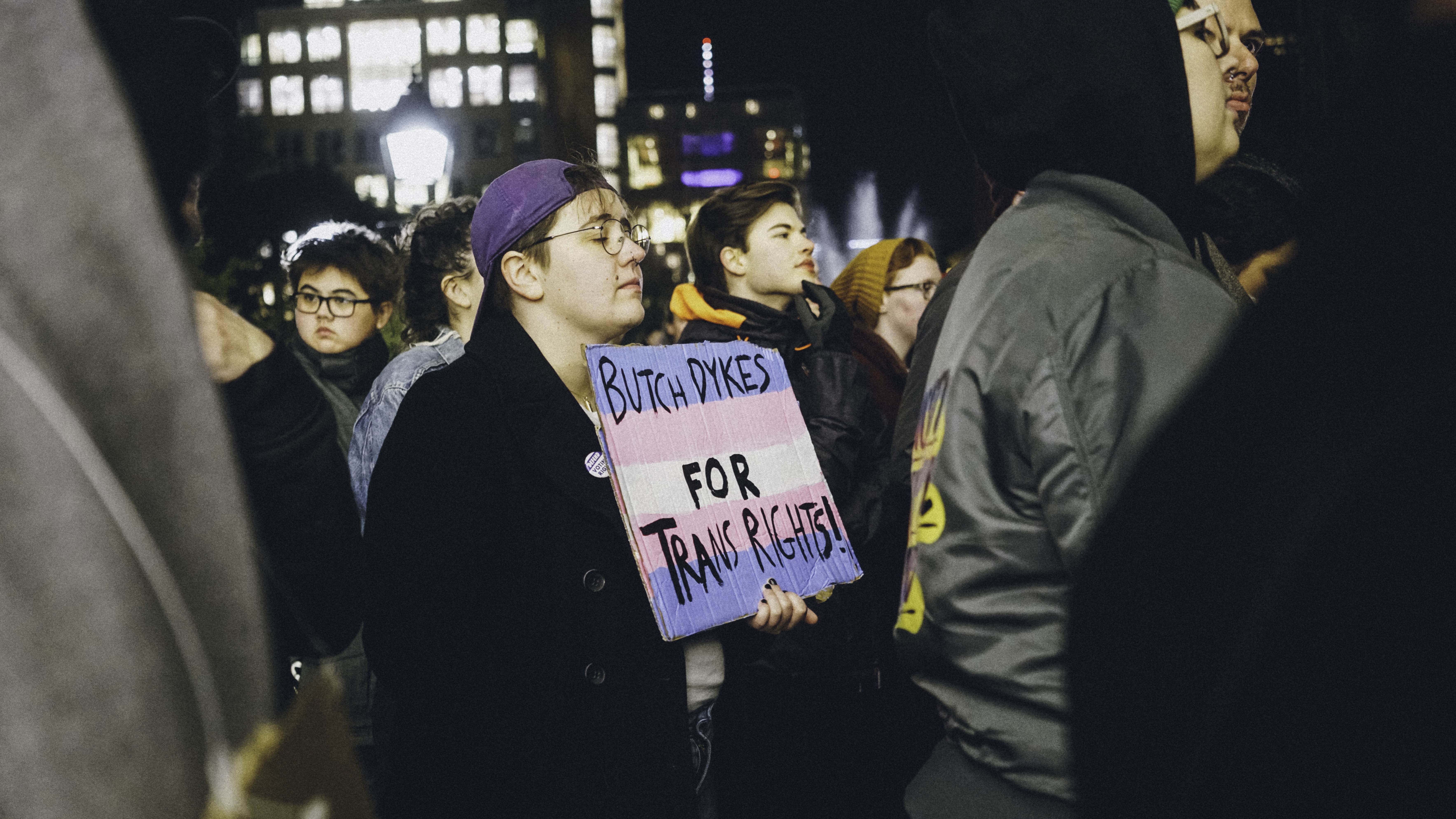 A person holding a sign that reads,