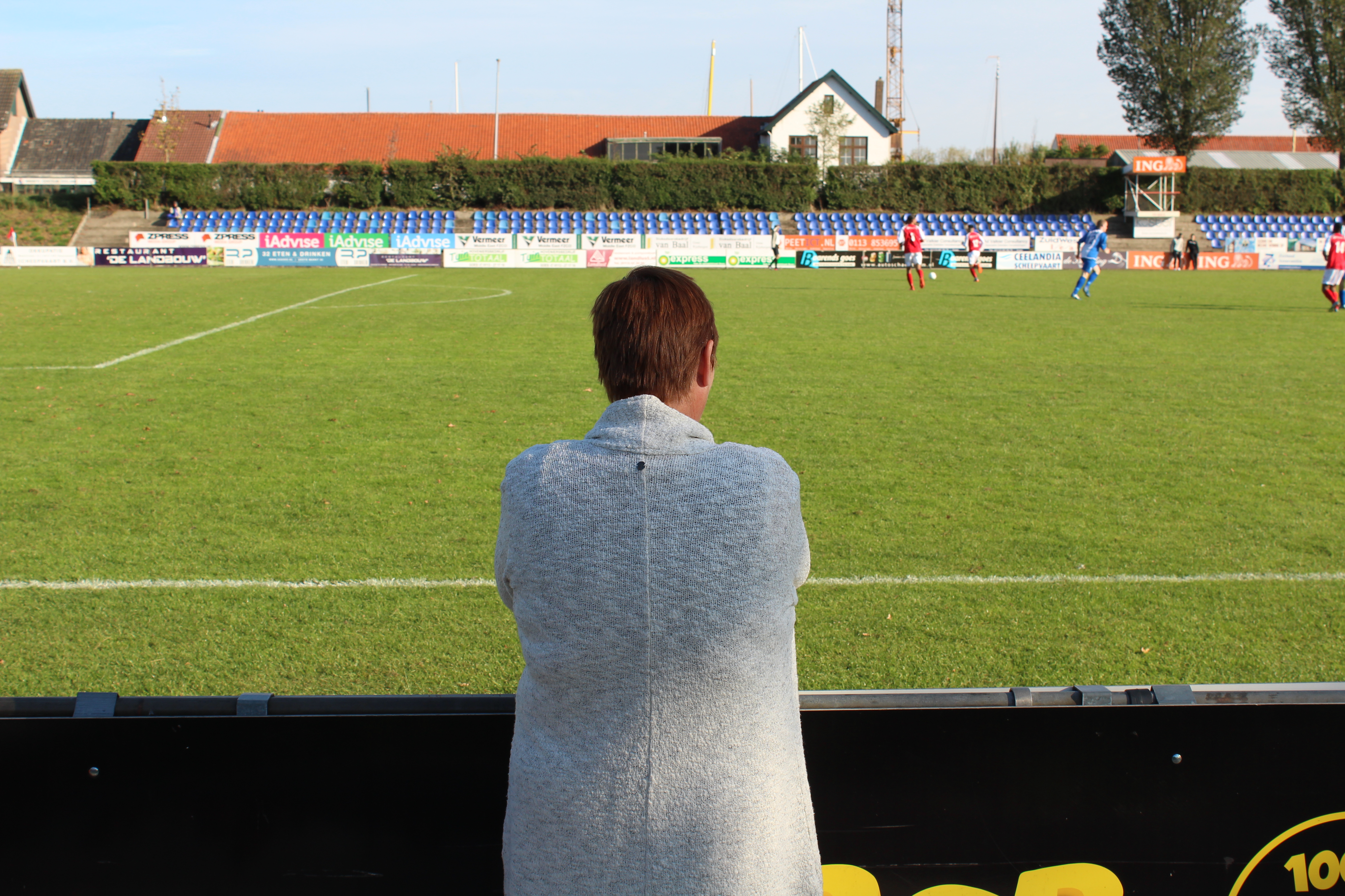 Een vrouw kijkt naar het hoofdveld van VV Goes.