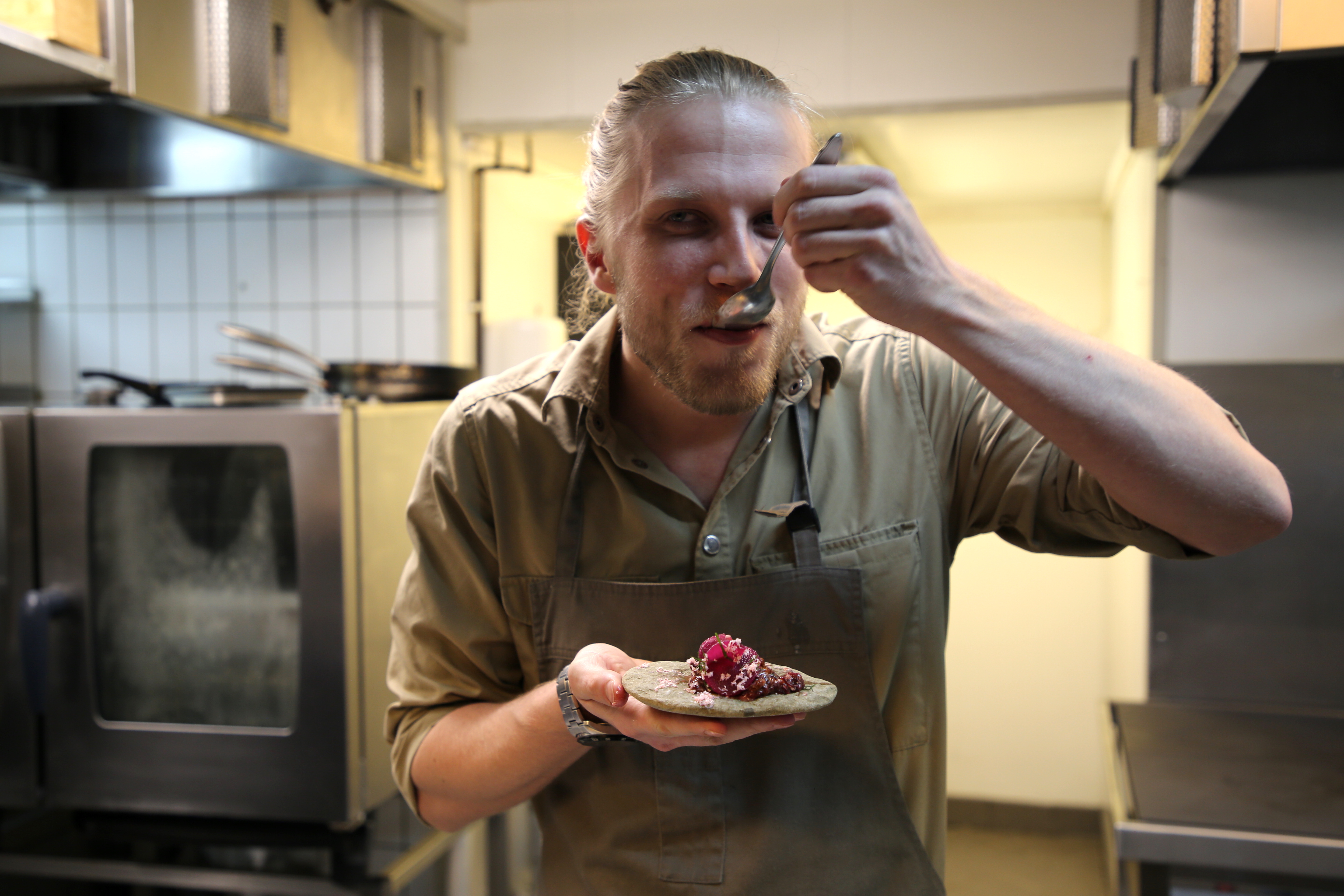 Andreas Langborg spiser i køkkenet på restaurant Huset på Svalbard.