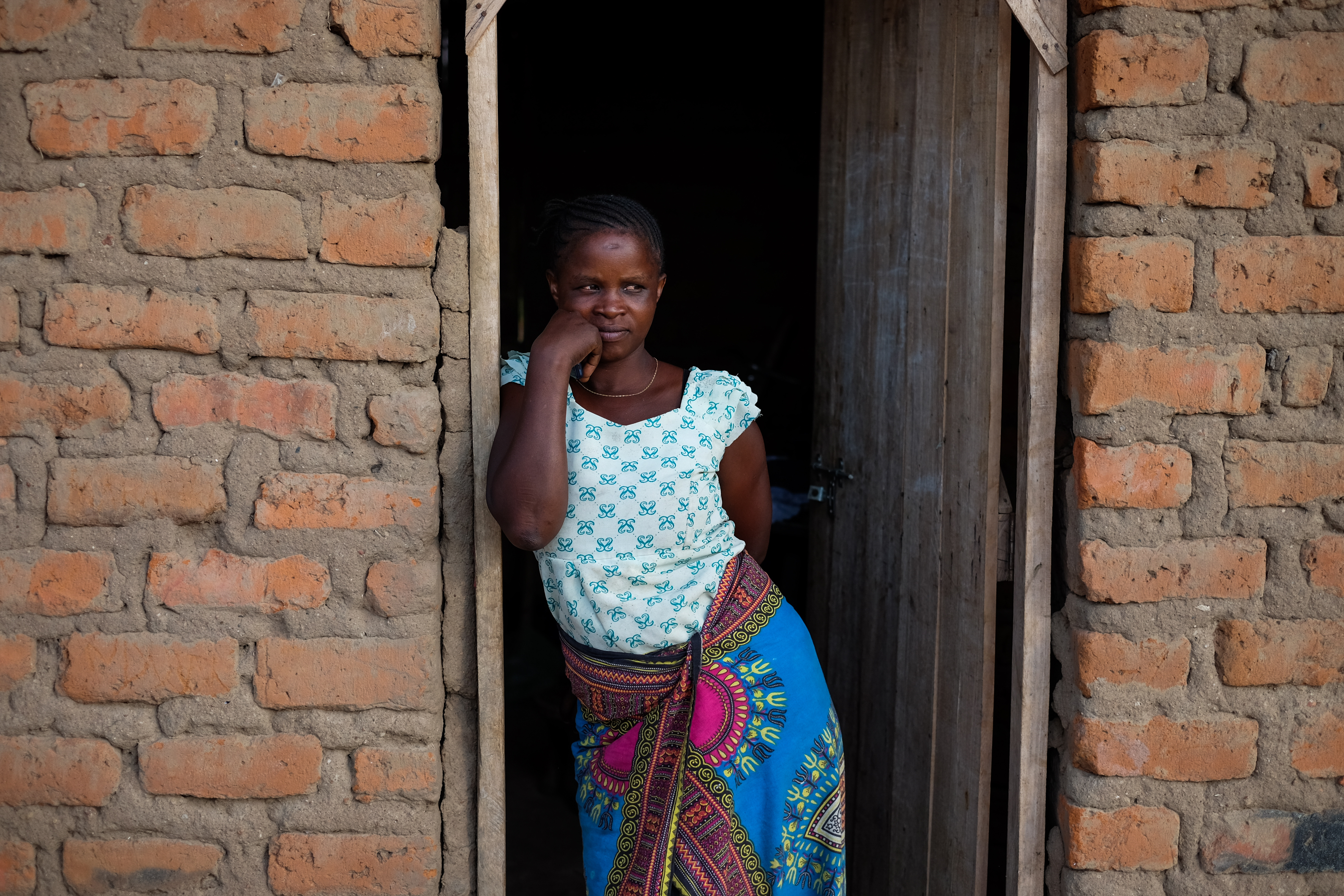 Robi Ester stands in the doorway of her home