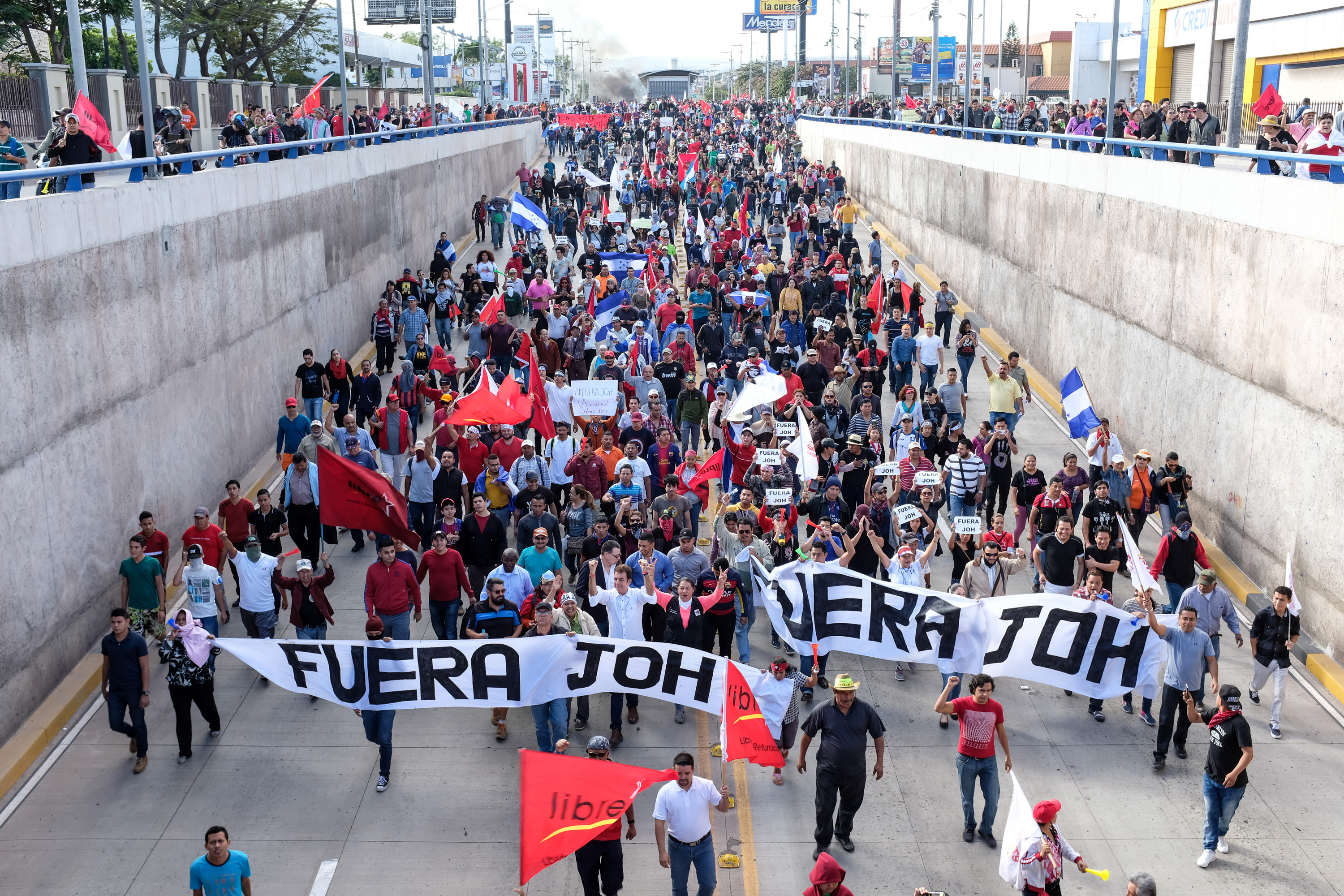 Protesters against Juan Orlando Hernandez march down a street