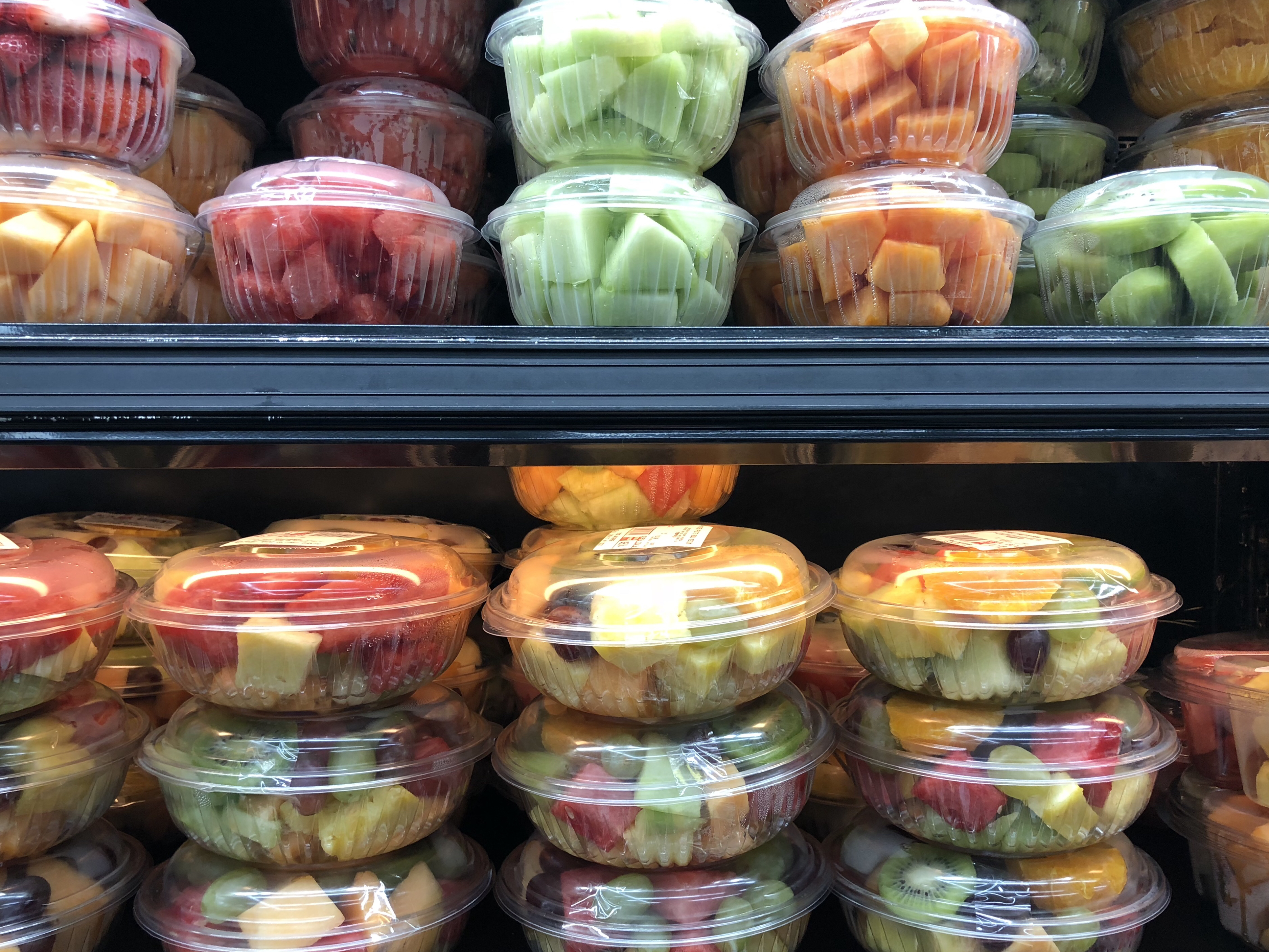 Chopped fruit in plastic containers at the grocery store.