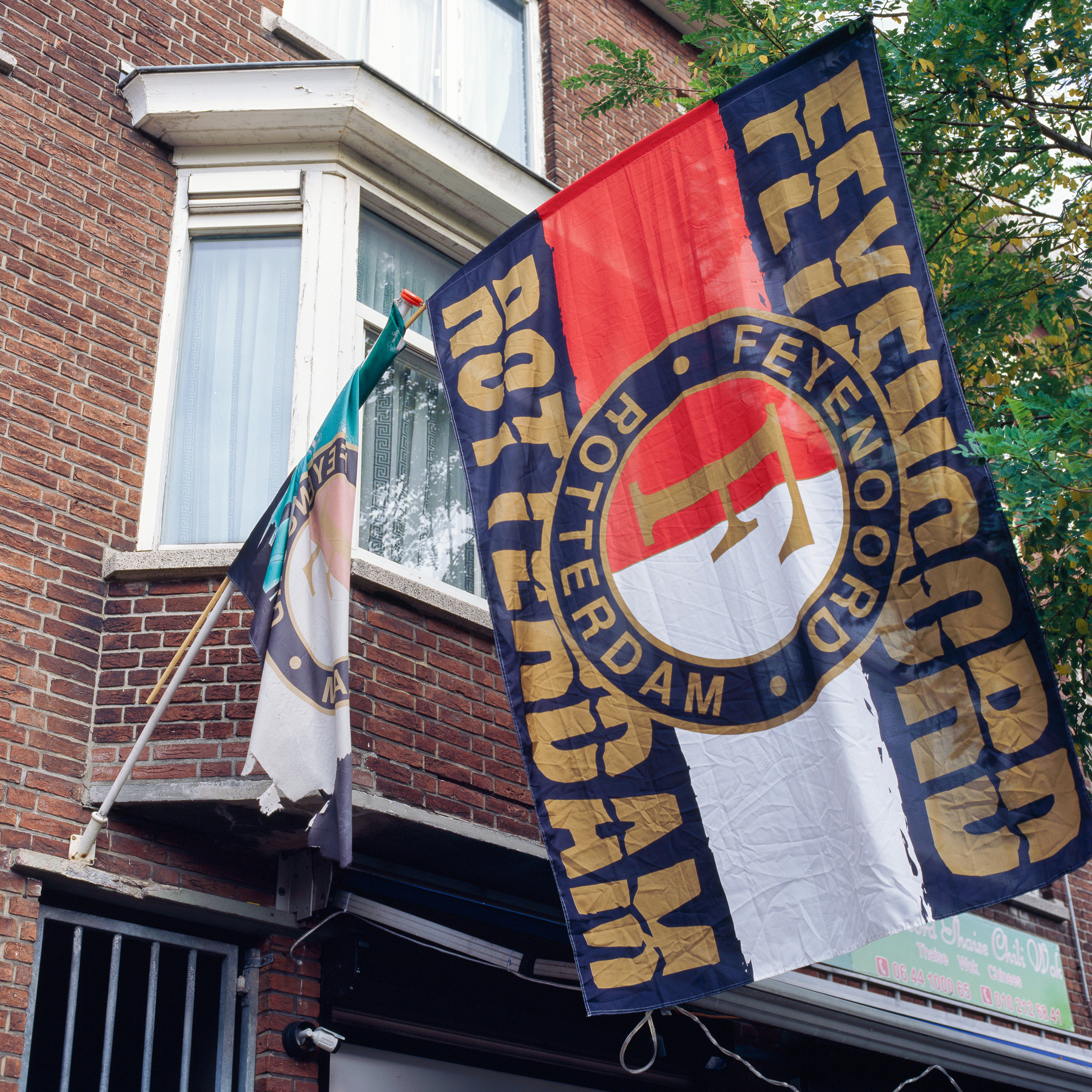Feyenoord-vlaggen aan de gevel.