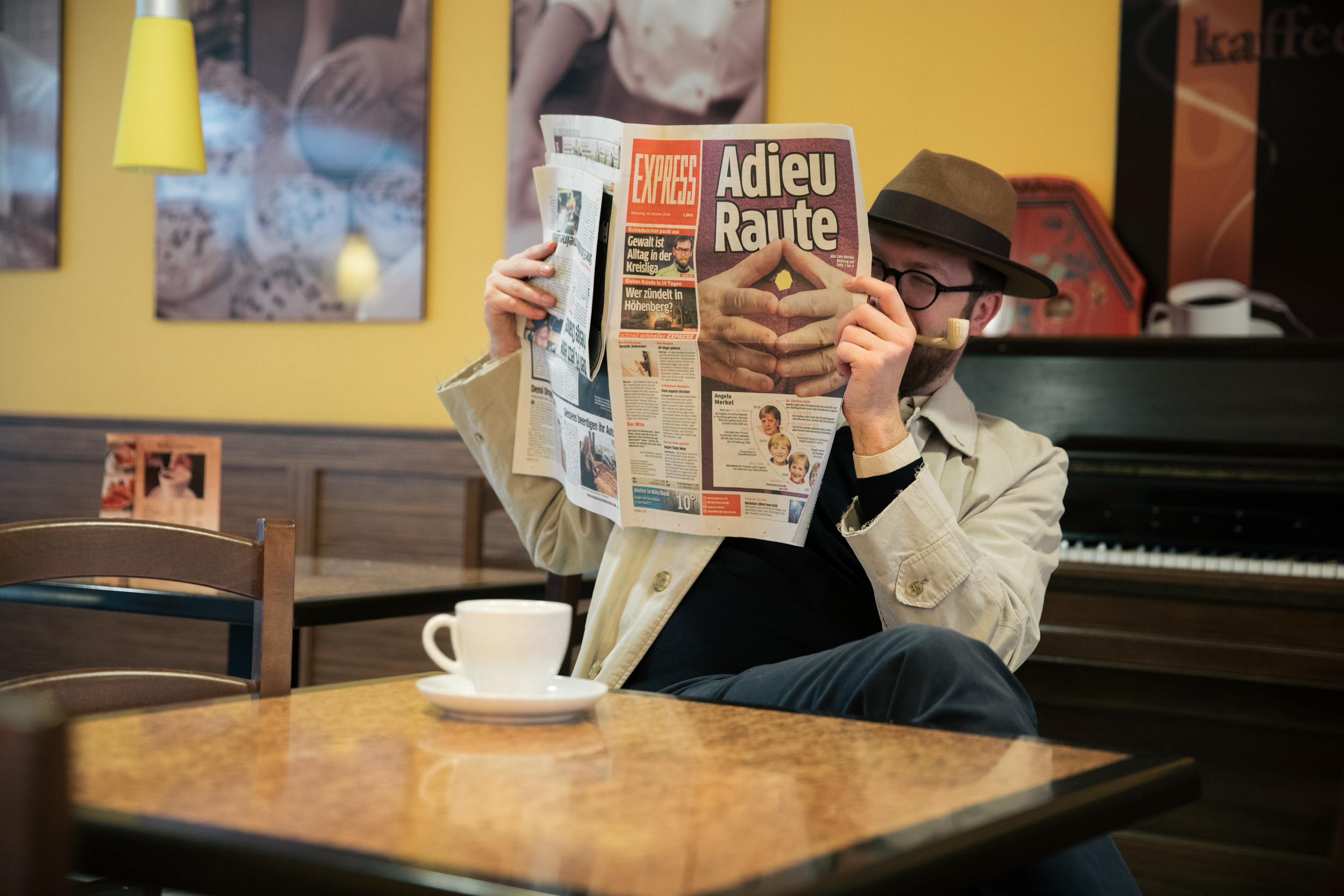Der Autor sitzt im Kaffee und liest eine Zeitung – doch die Zeitung hat ein Loch!