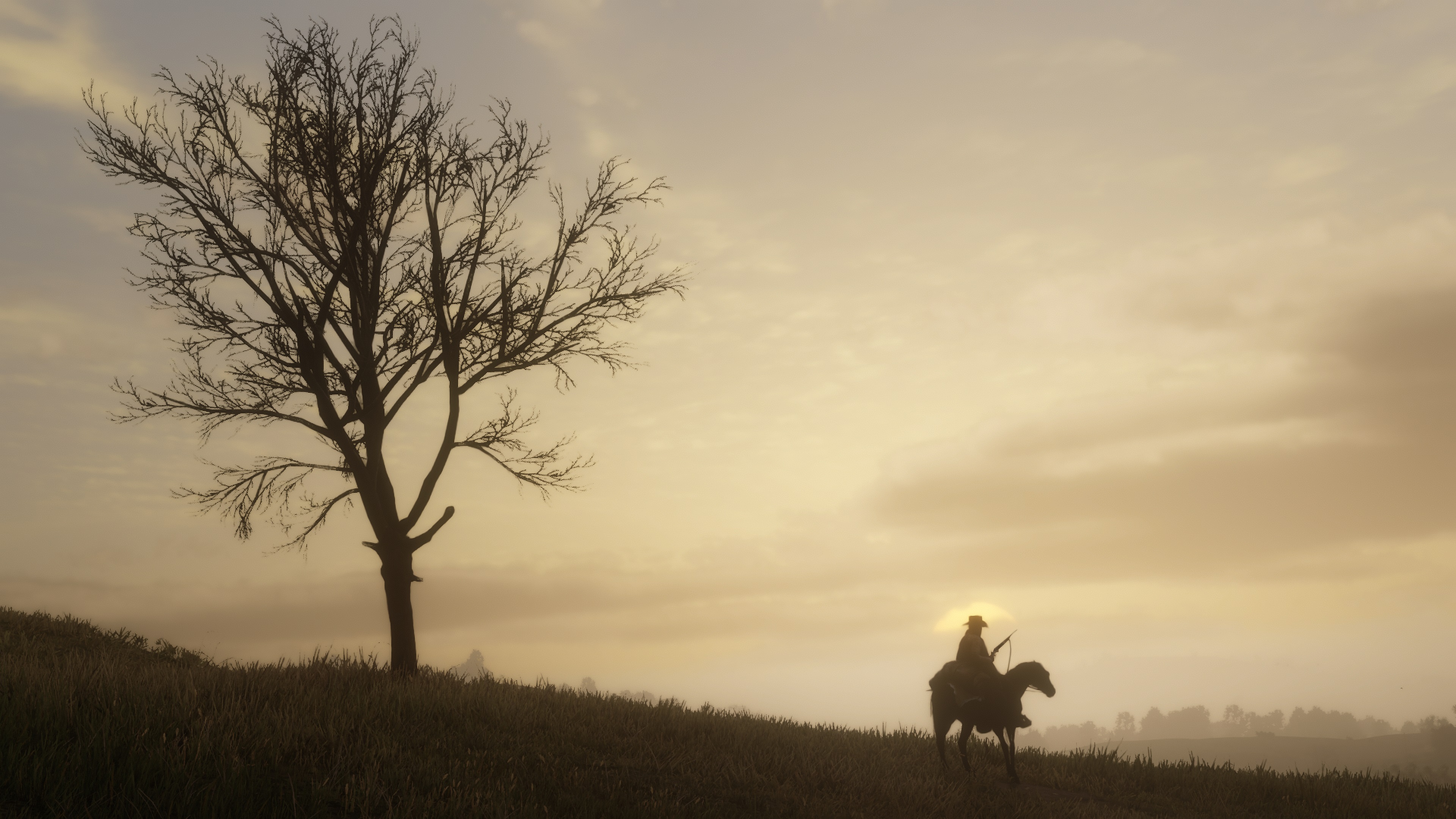 A barren tree juts from a hillside at the left of the frame, silhouetted against a sky turning tan and gold with the sunset, while further down the slope sits a solitary horseman.