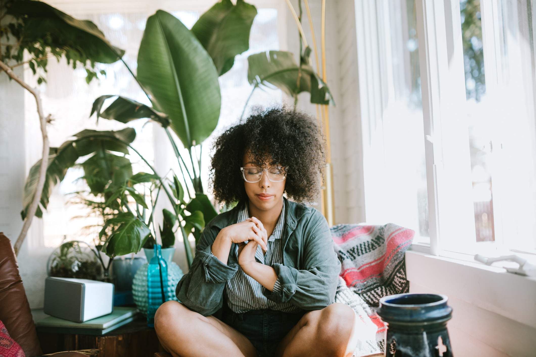 Woman meditating at home Photo by Getty Images / RyanJLane
