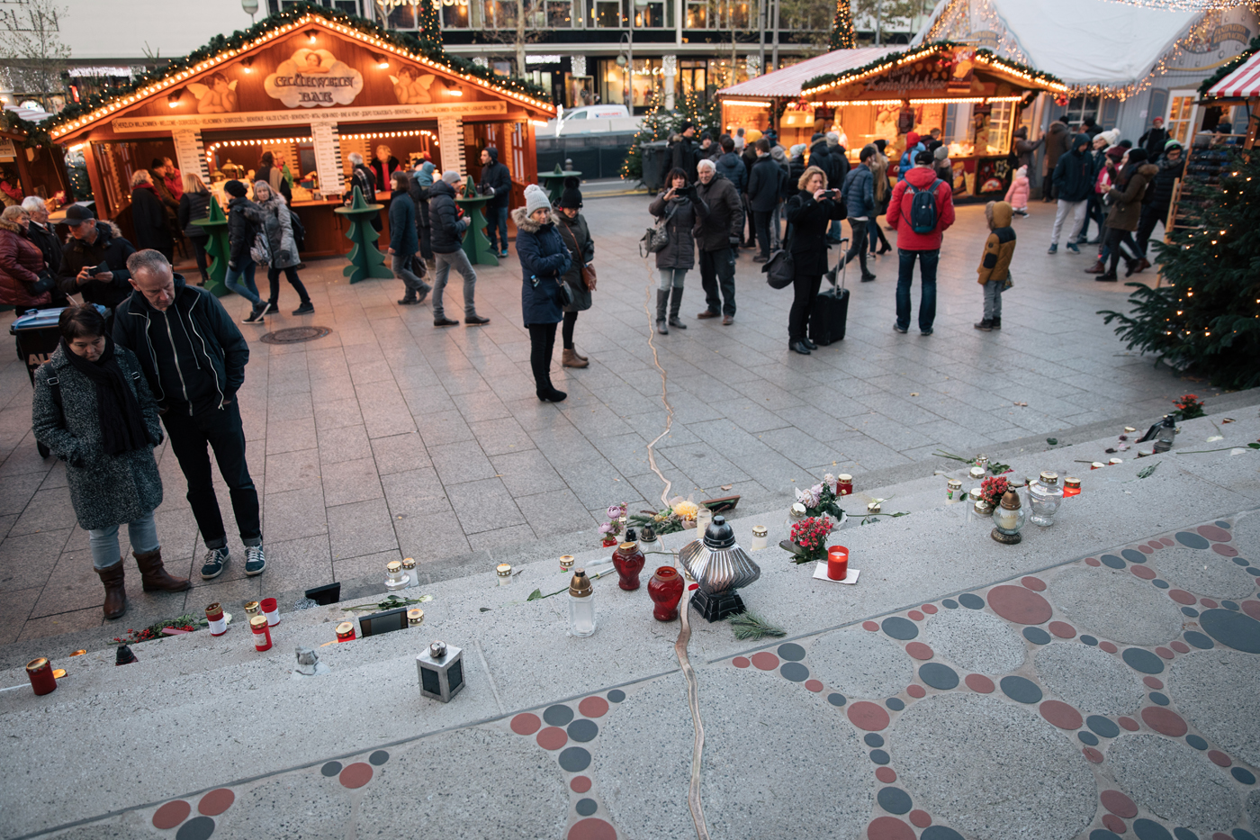 Menschen stehen vor der Treppe, in die die Namen der Opfer eingelassen sind