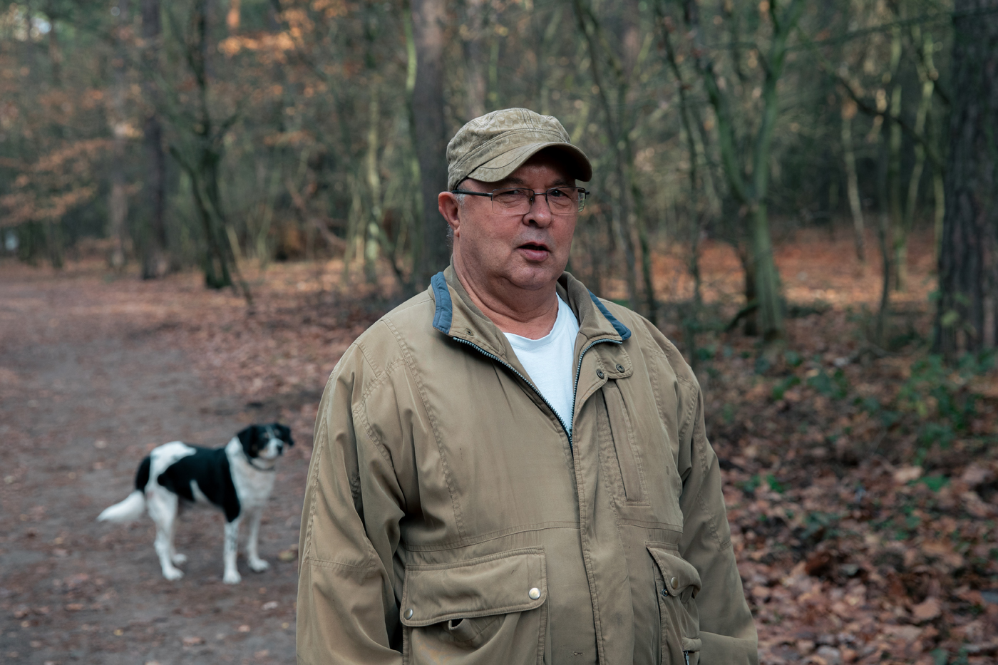 Ein Mann und ein Hund stehen auf einem Waldweg in Müggelheim