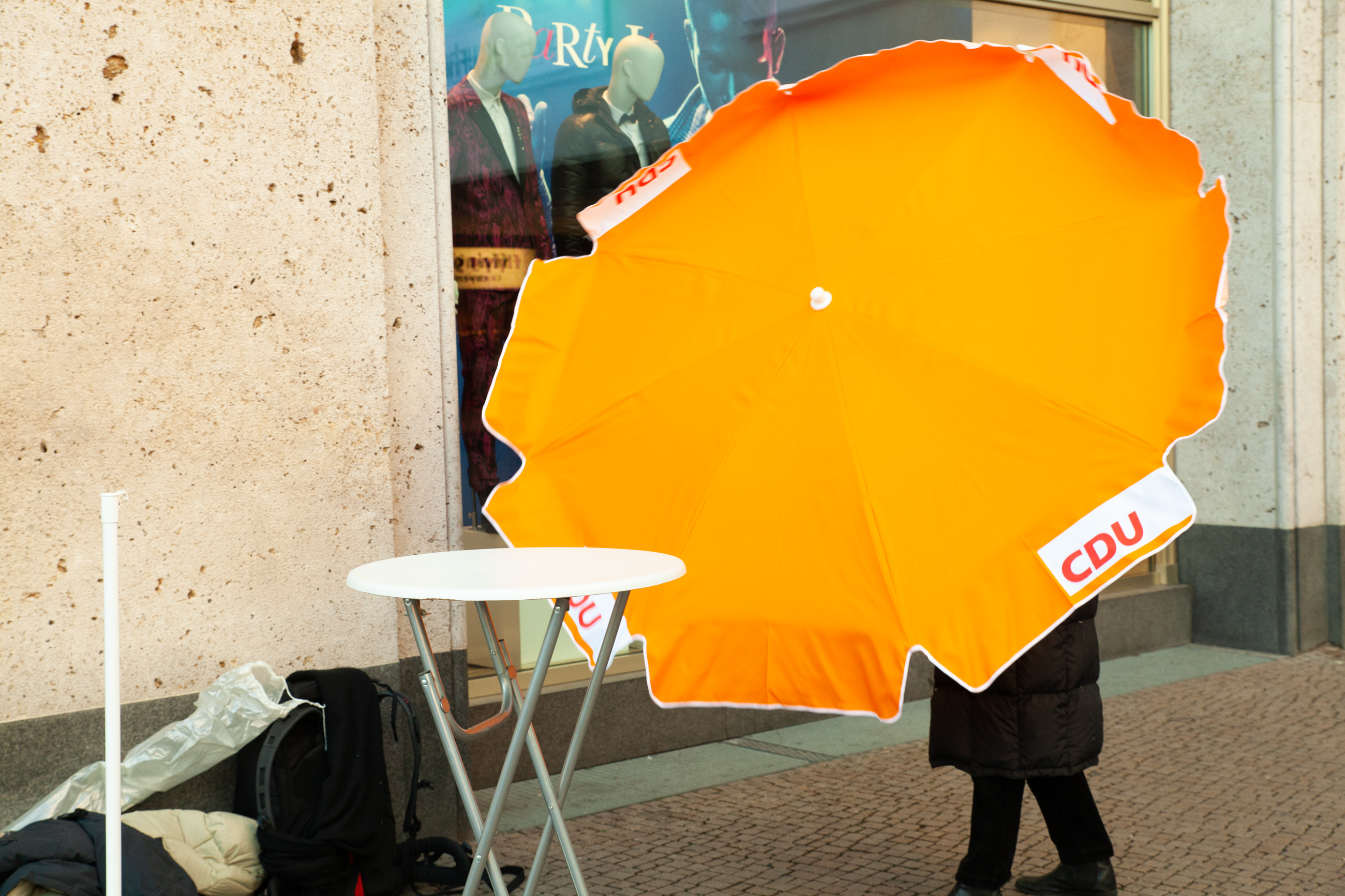 Jemand hantiert mit einem CDU-Sonnenschirm auf dem Alexanderplatz