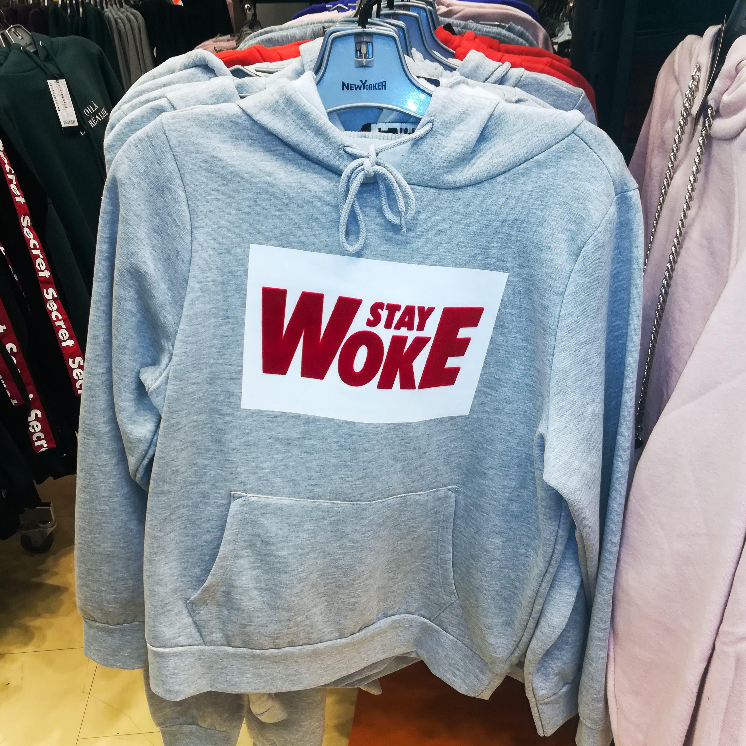 Grå hættetrøje med rød påskrift: Stay Woke