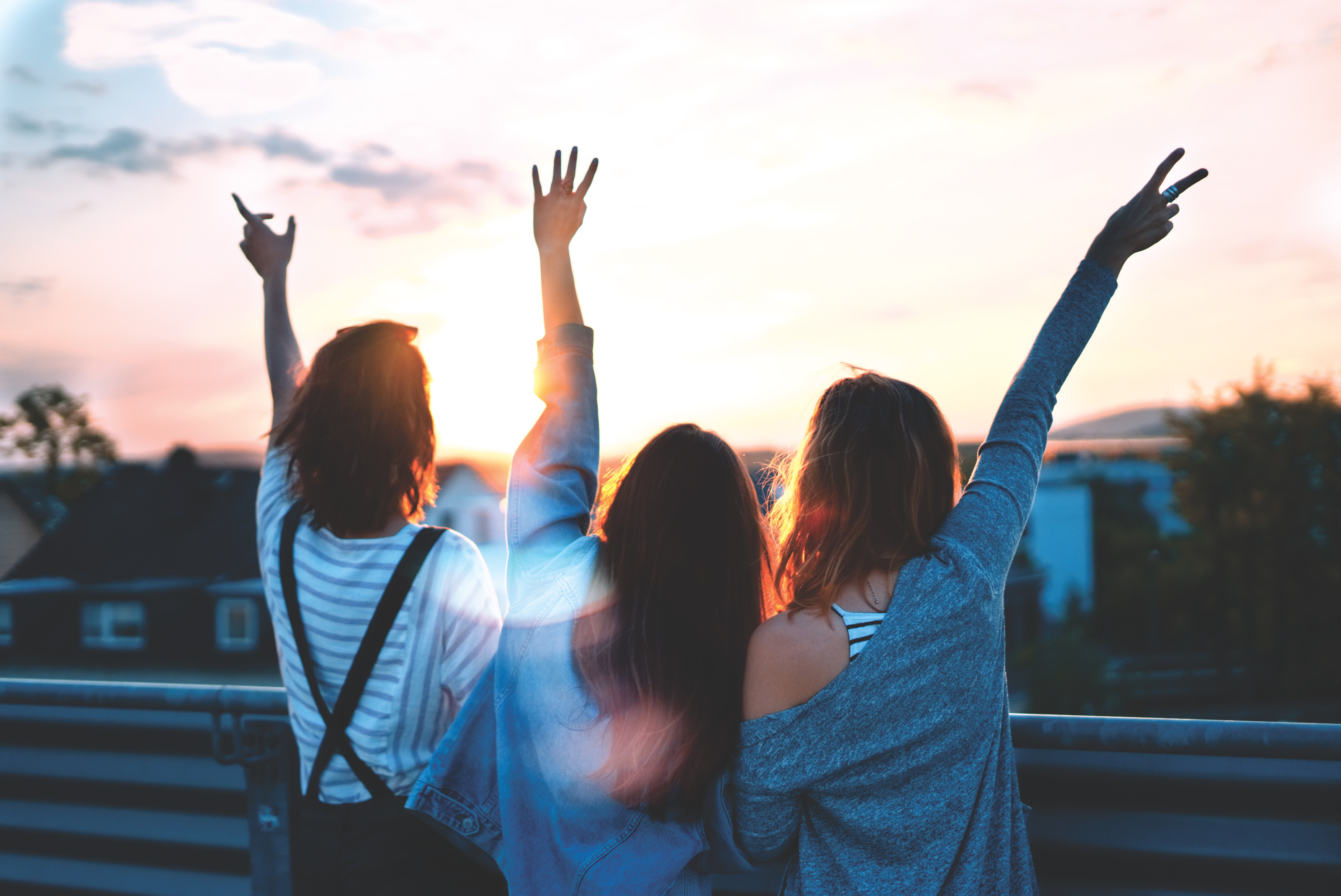 Female friends posing in front of a sunset