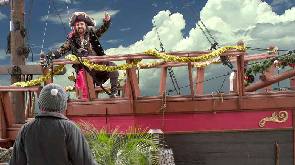 A man dressed as a pirate, standing on a pirate ship.