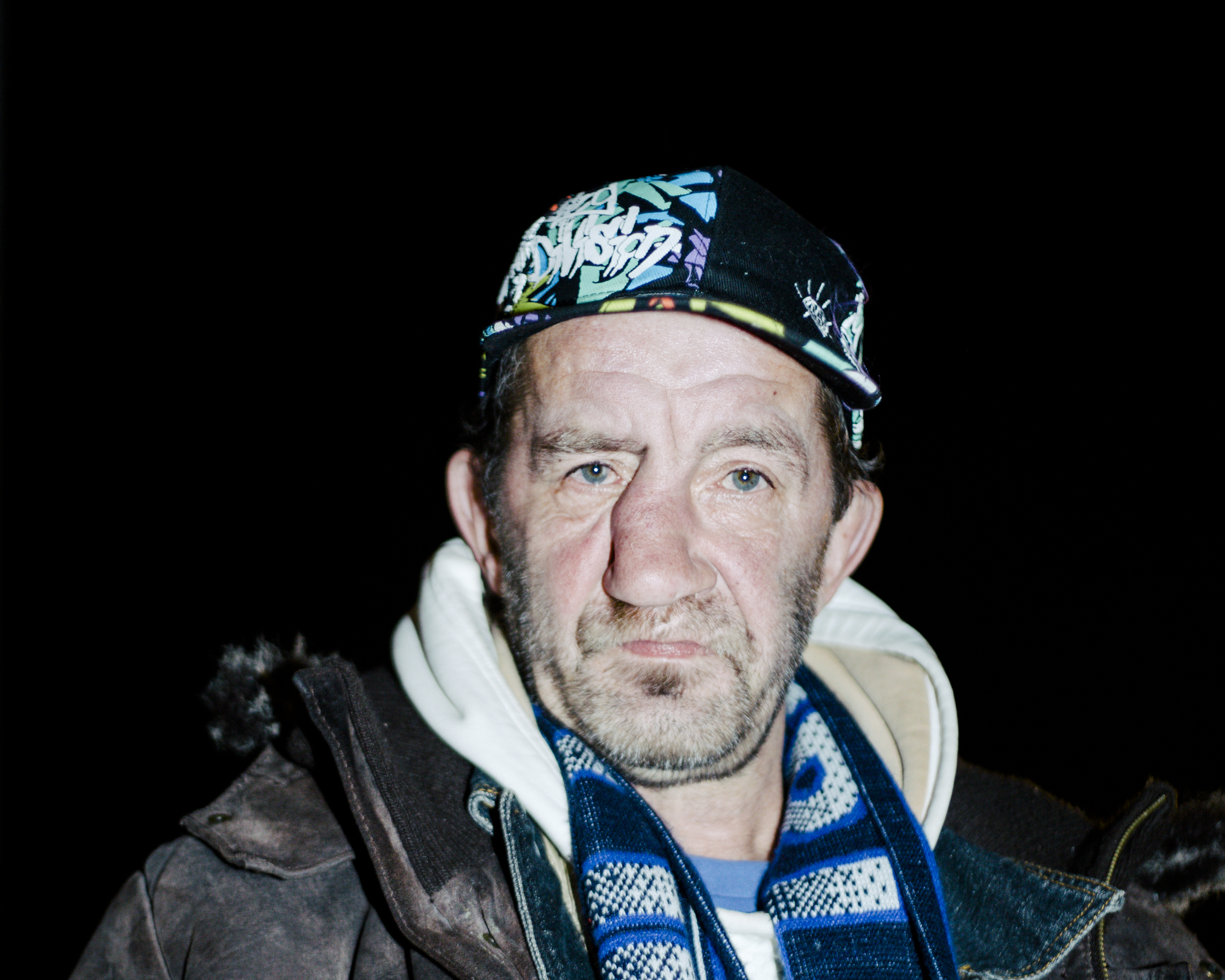 Ein obdachloser Mann mit Kappe und Hertha BSC-Schal