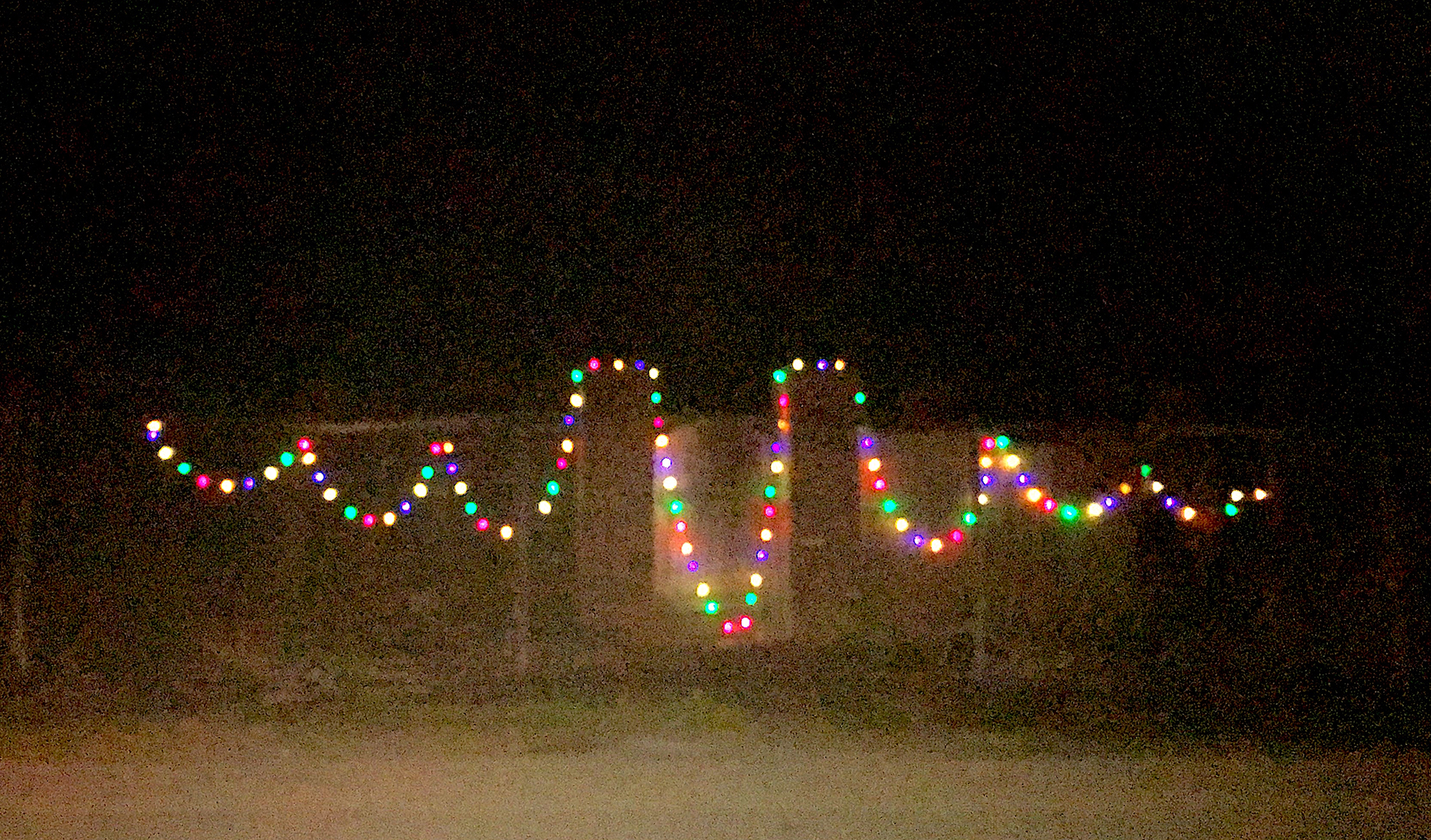 A string of christmas lights on a fence