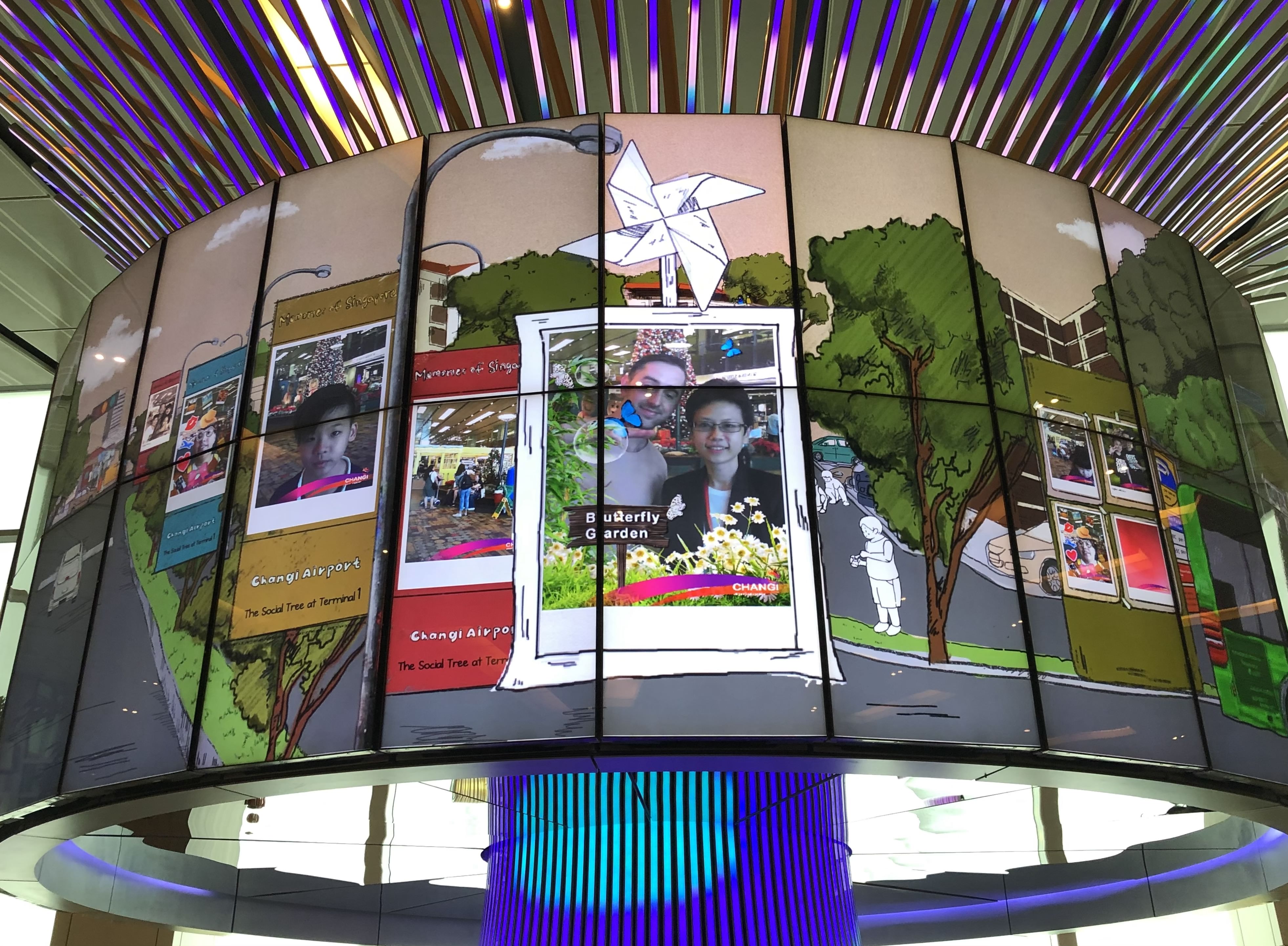 An lcd screen displays photo booth pictures of travelers