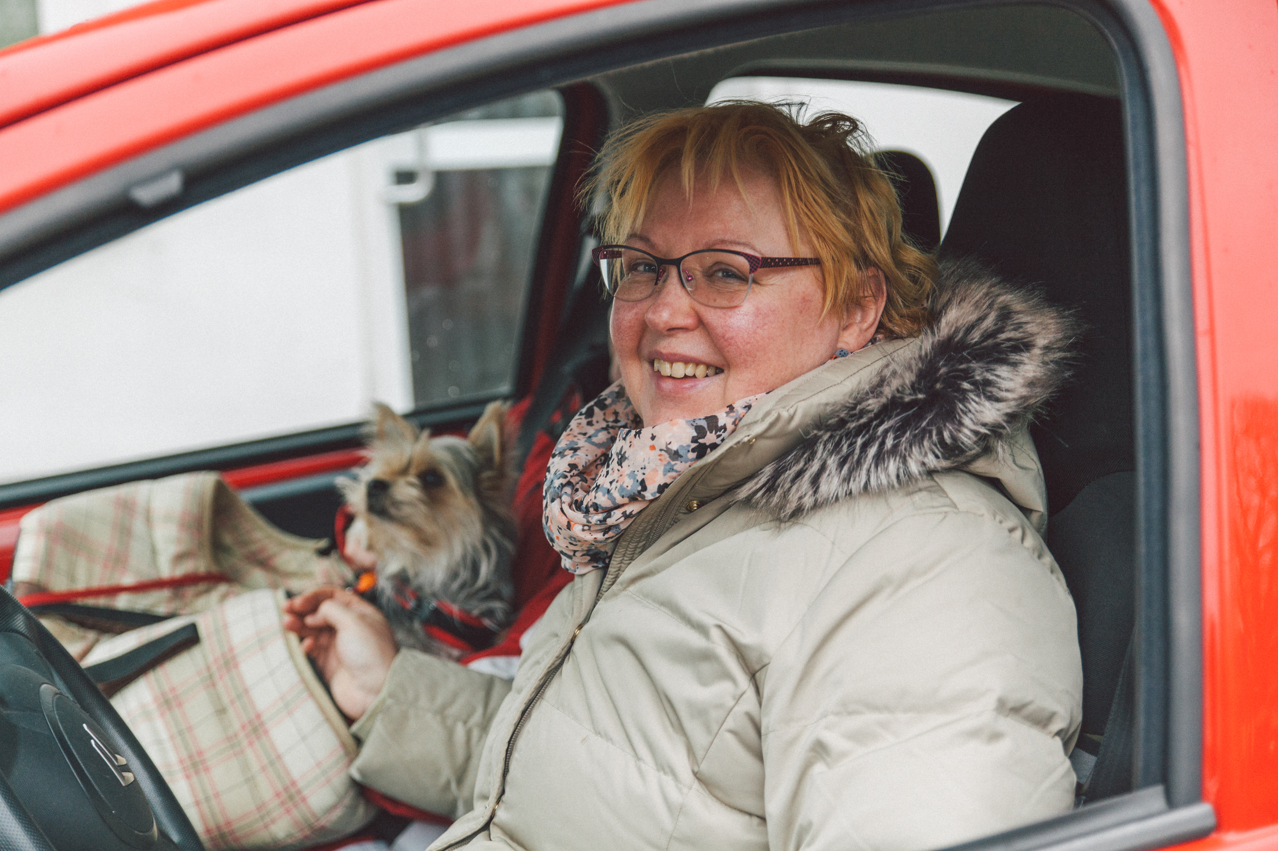 Eine Frau in ihrem Auto bietet sich als Mitfahrgelegenheit an