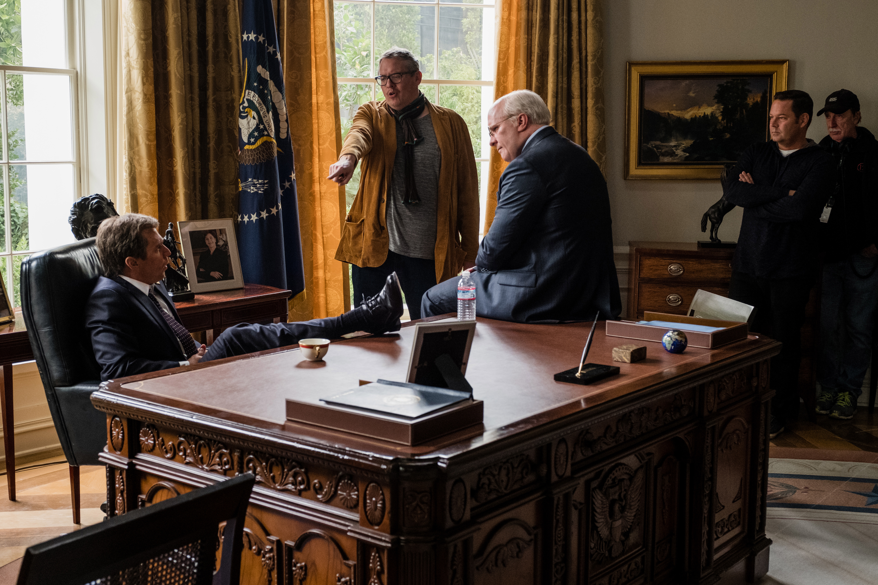 Director Adam McKay (center) with Christian Bale (right) and Sam Rockwell (seated) on the set of 'VICE.' Images courtesy of Annapurna Pictures