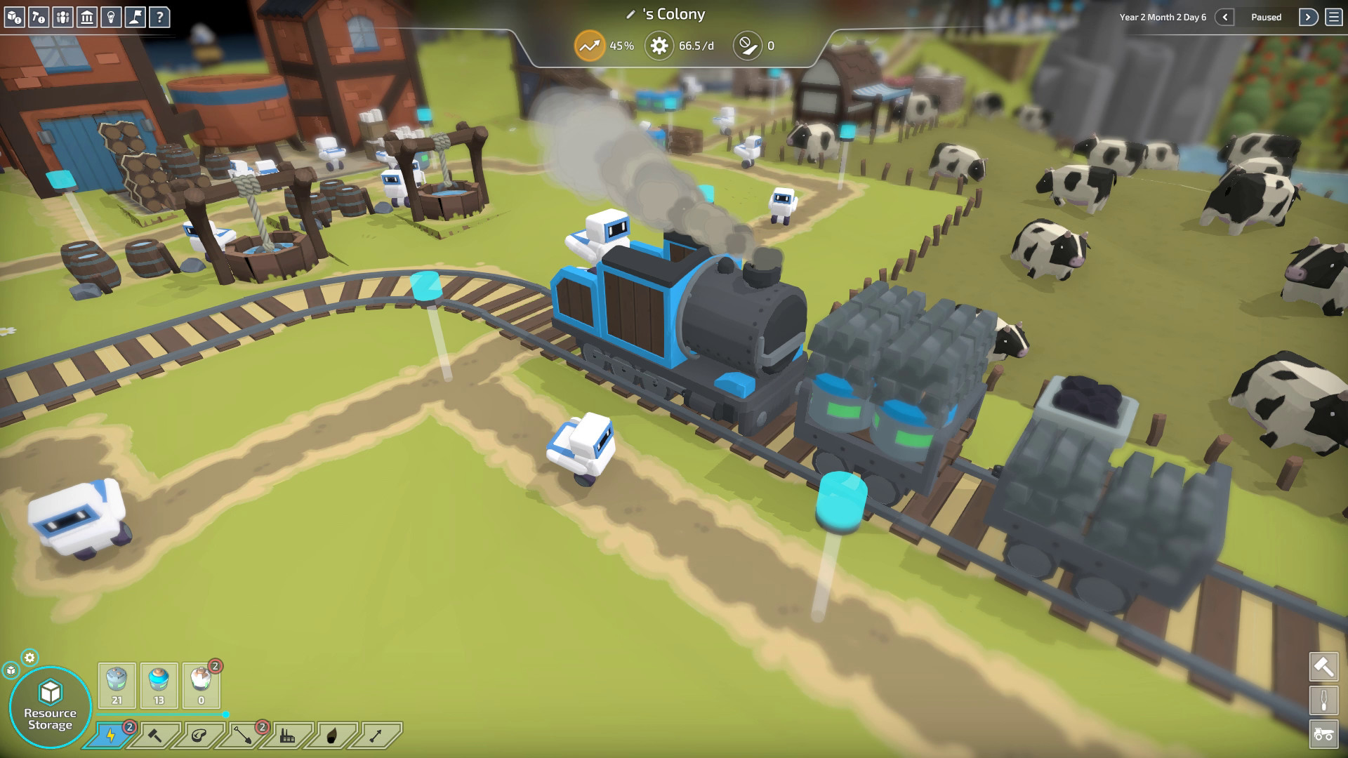 A little robot train runs across a green landscape.