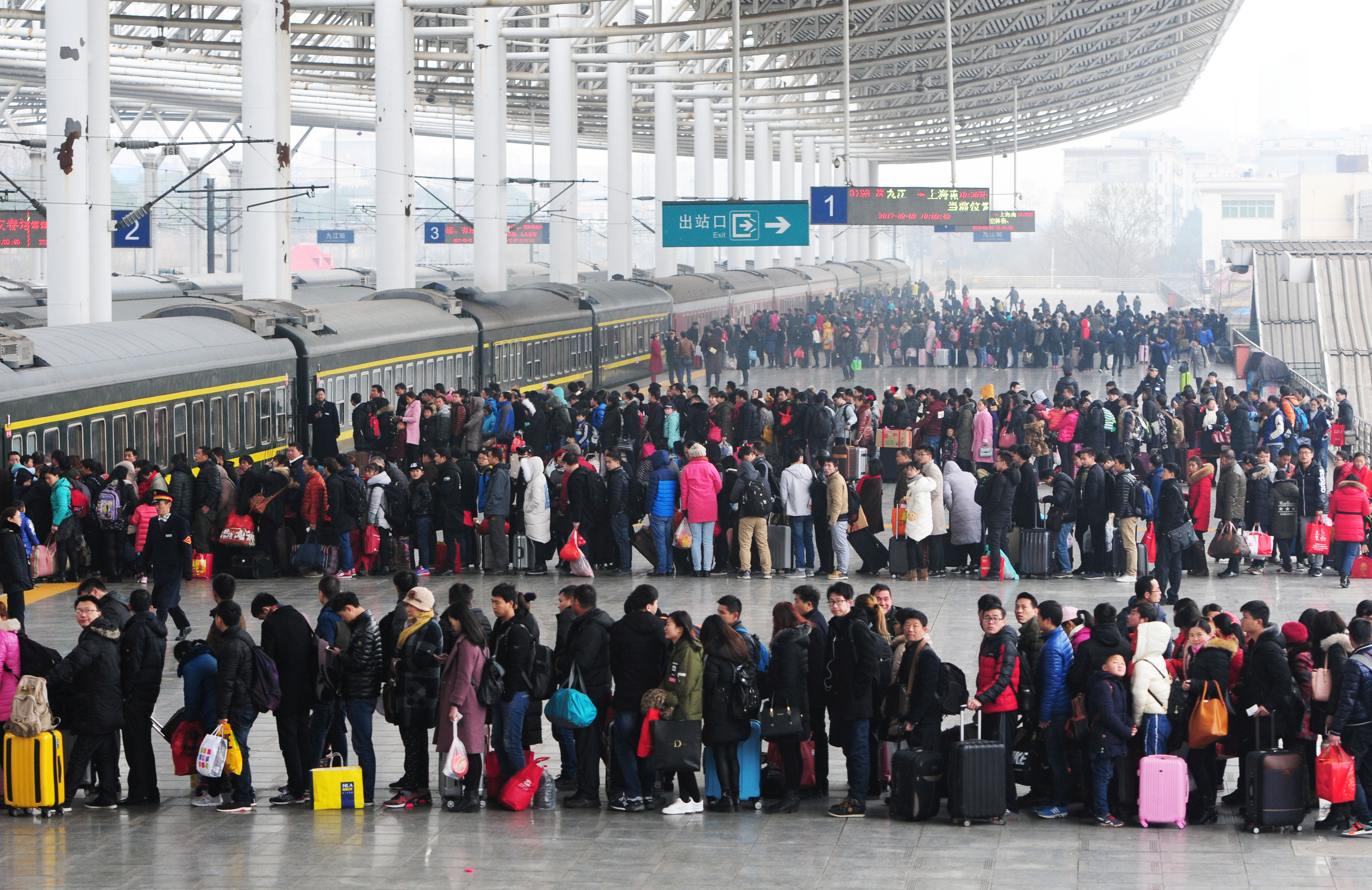 People wait to board a train on the last day of Chinese Lunar New Year holidays at a railway station in Jiujiang.
