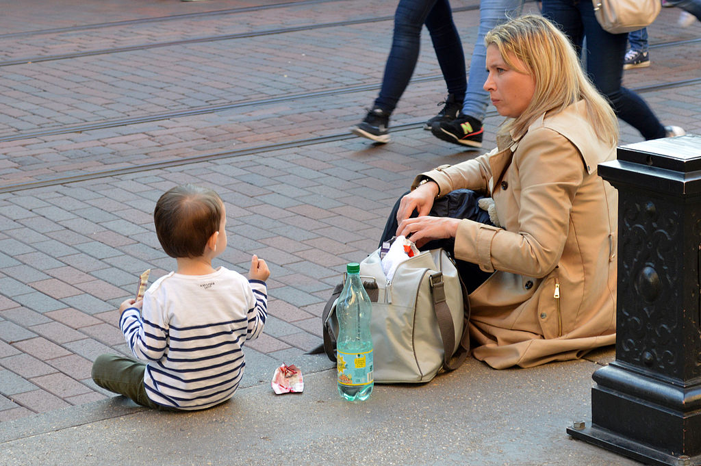 Mother_and_child_sitting_on_the_pavement