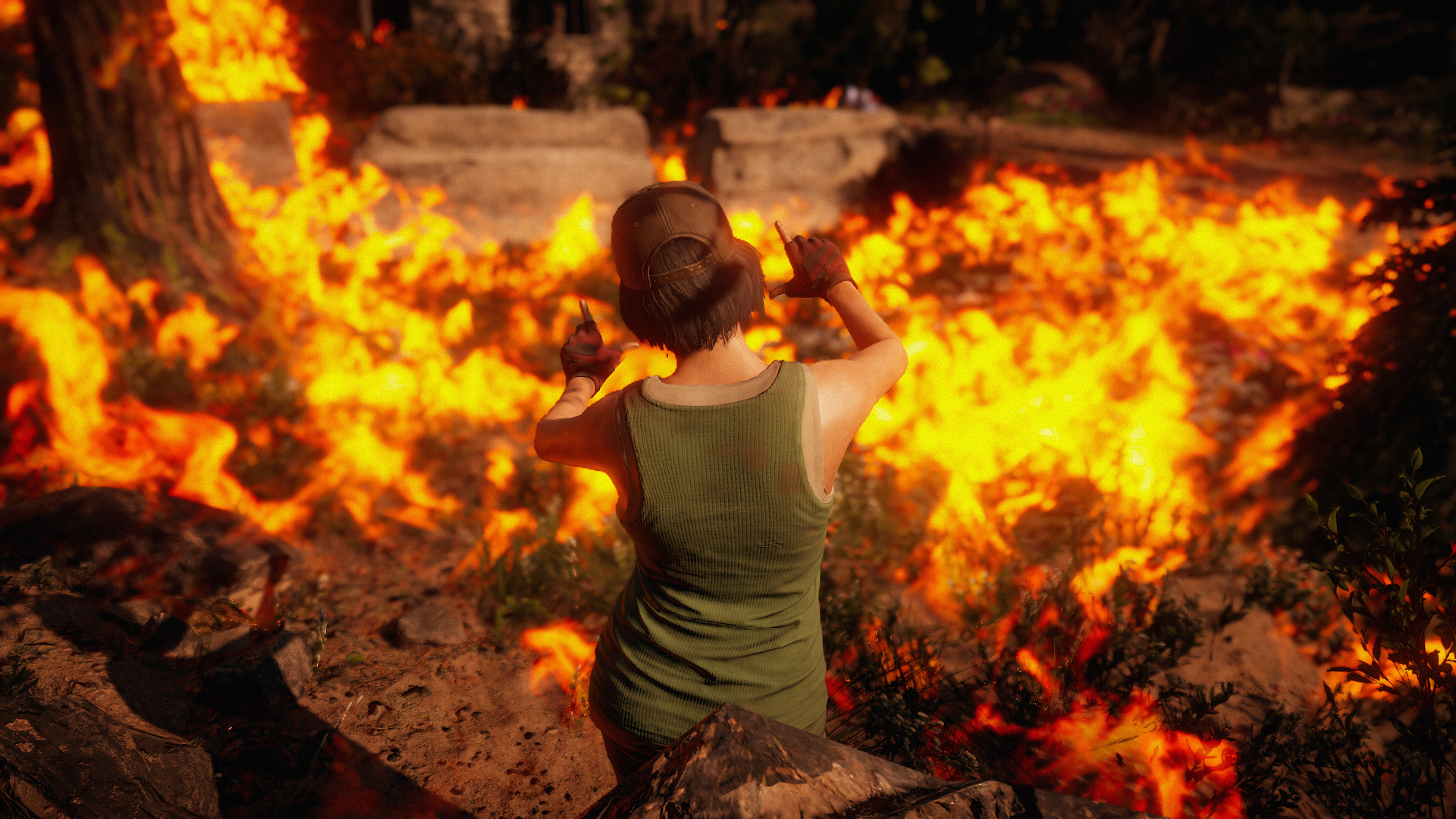 A Far Cry: New Dawn character composes an image before a burning field, arms and fingers outstretched to mimic the frame of a camera.