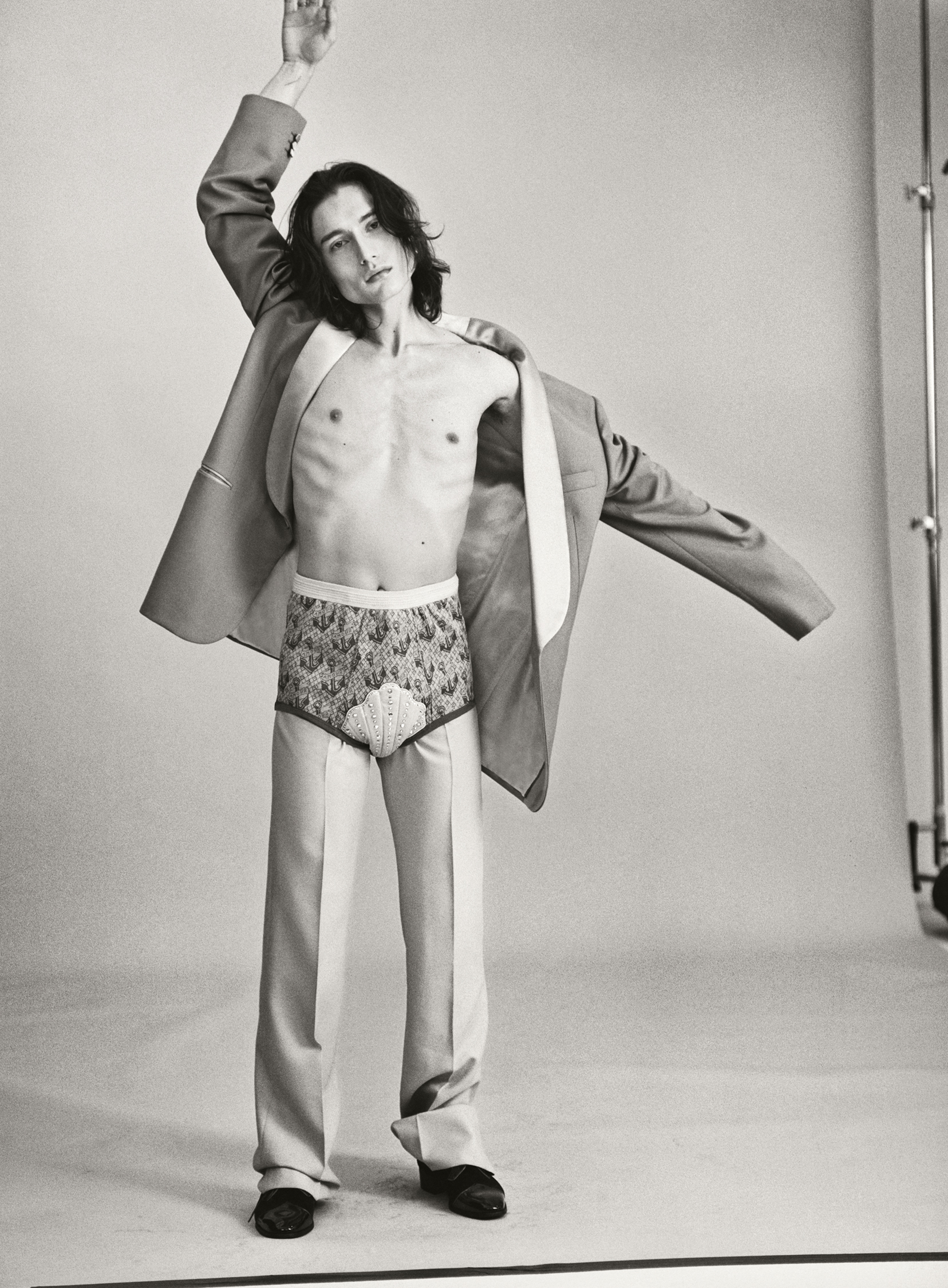 Cameron wears jacket, trousers, briefs, and shoes by GUCCI.