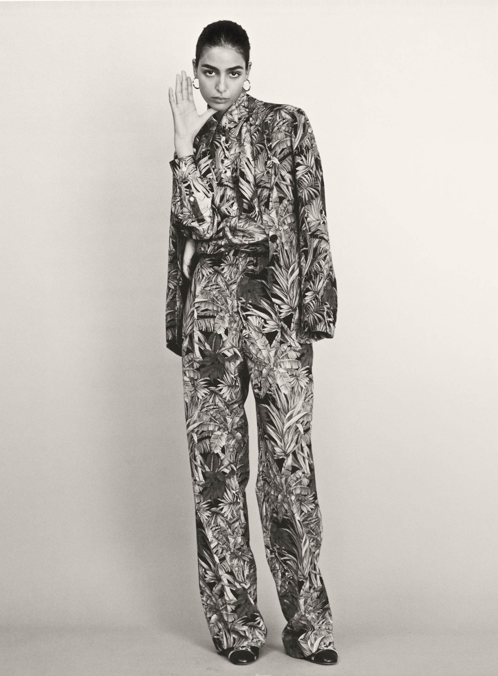 Jacket, shirt, and trousers by SALVATORE FERRAGAMO, earrings by HORIZONS VINTAGE.