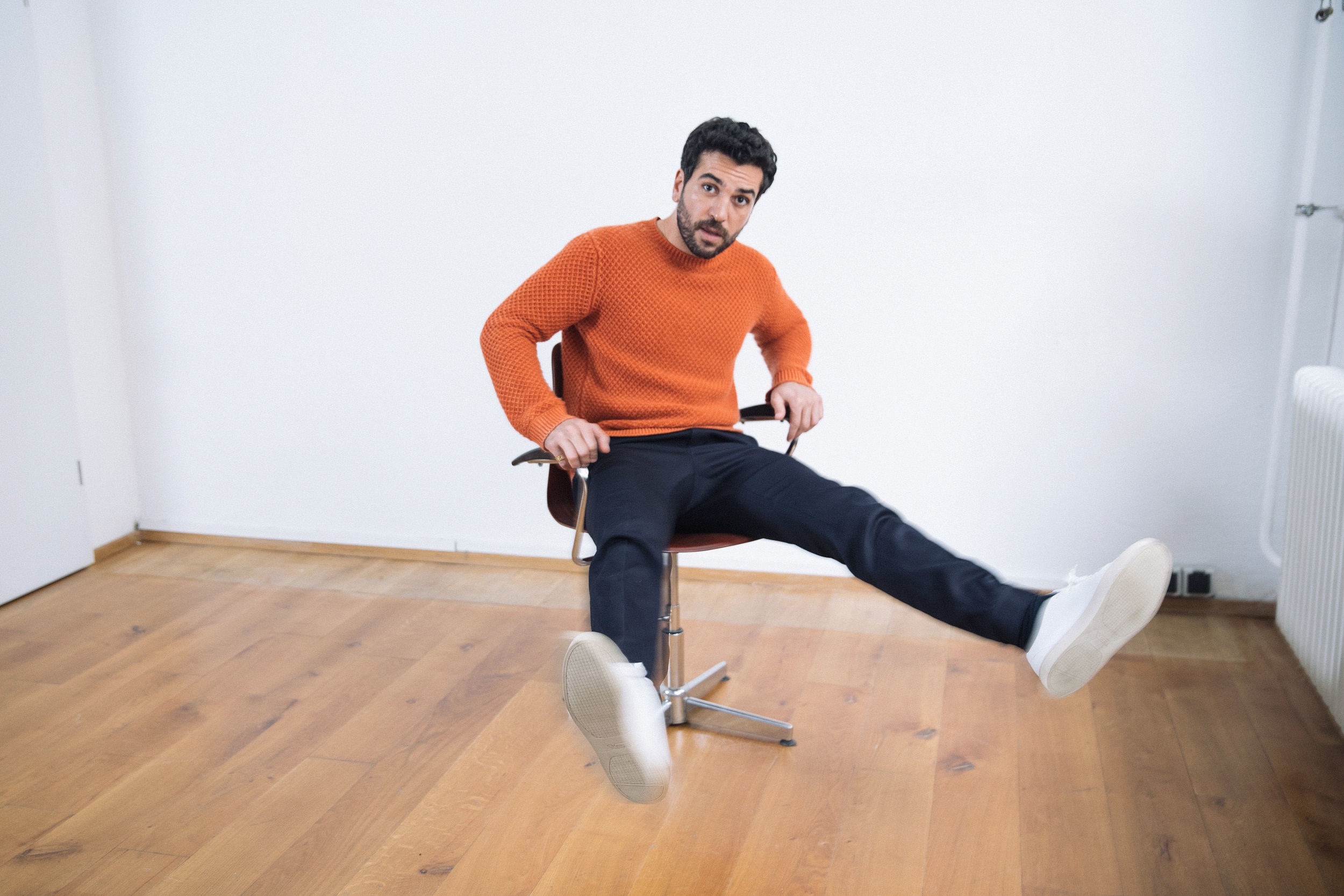Elyas M'Barek dreht sich auf einem Bürostuhl