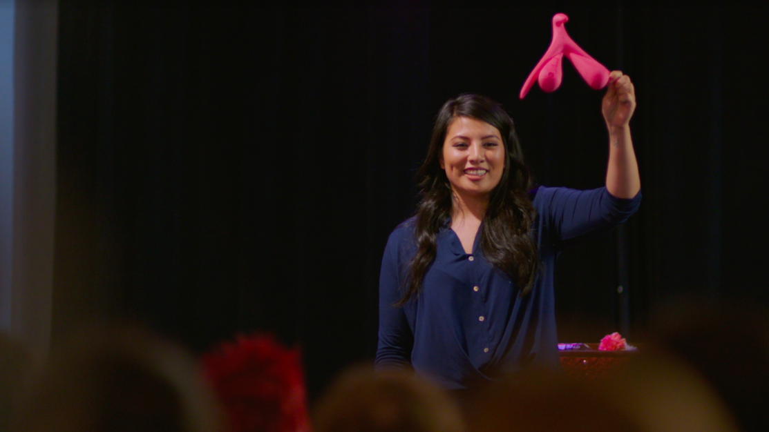 Andrea Barrica holding up a clitoris figure