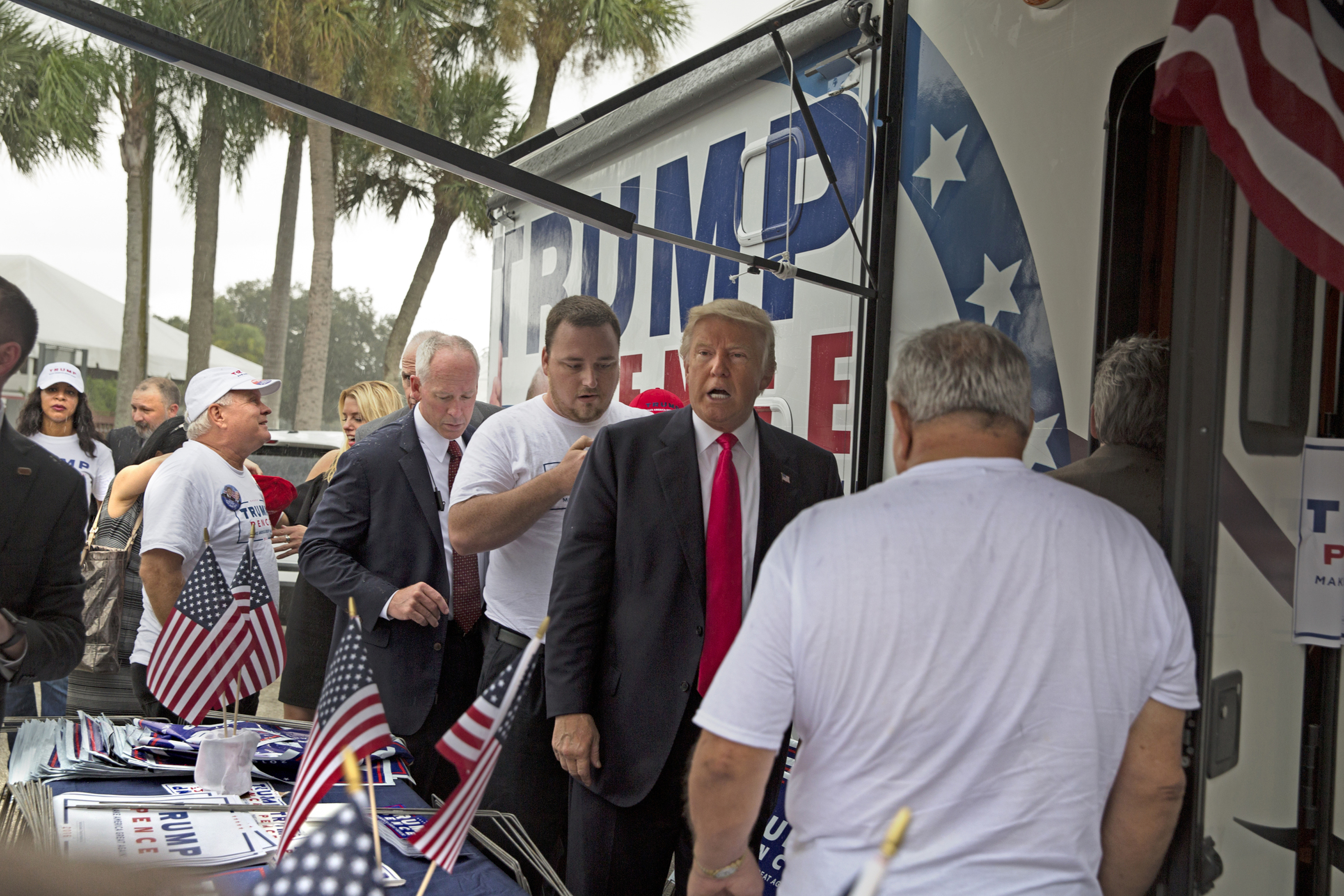 In an Aug. 24, 2016 photo, Republican presidential nominee Donald Trump meets supporters organizing voter registration and support for his campaign just before a rally at the Florida State Fairgrounds in Tampa, Fla. A woman is alleging in a new lawsuit filed Monday, Feb. 25, 2019, that Inside the RV seen here, Trump kissed a member of his campaign staff without consent. The woman, Alva Johnson, can be seen in the background of this photo wearing a Trump shirt and a hat on the left side of the frame.(Loren Elliott/Tampa Bay Times via AP)