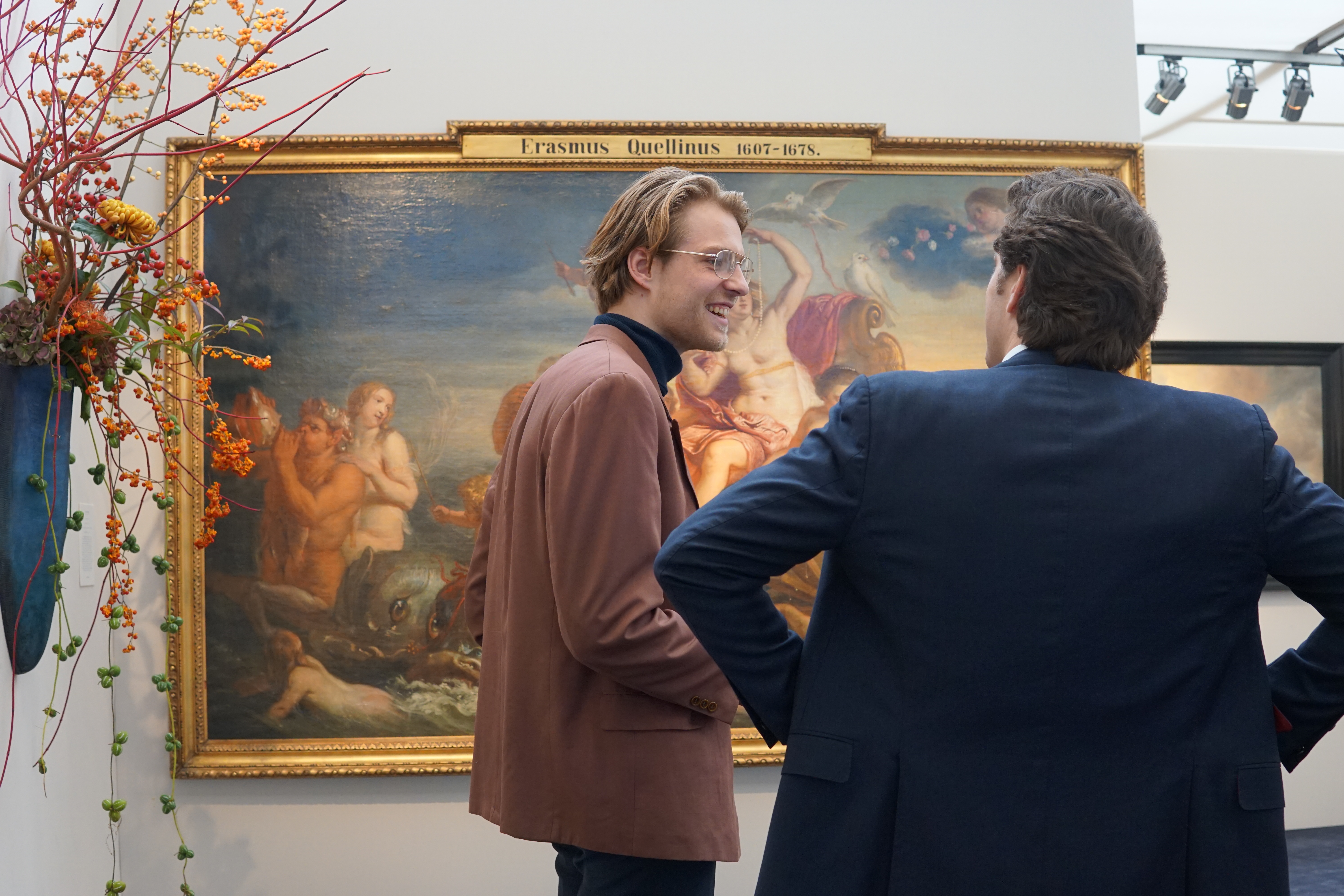 man staat samen met andere man voor schilderij