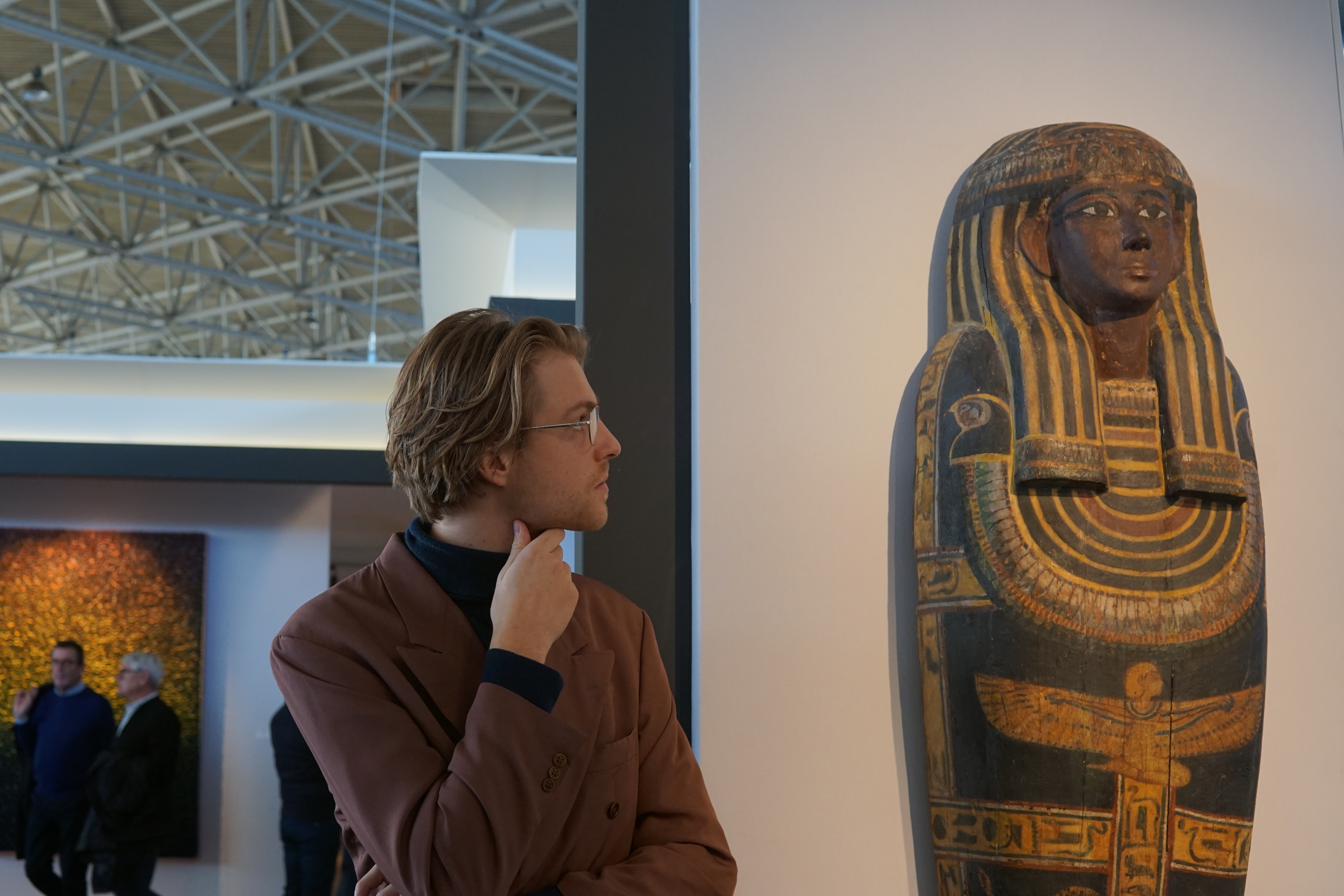 man naast een farao beeld