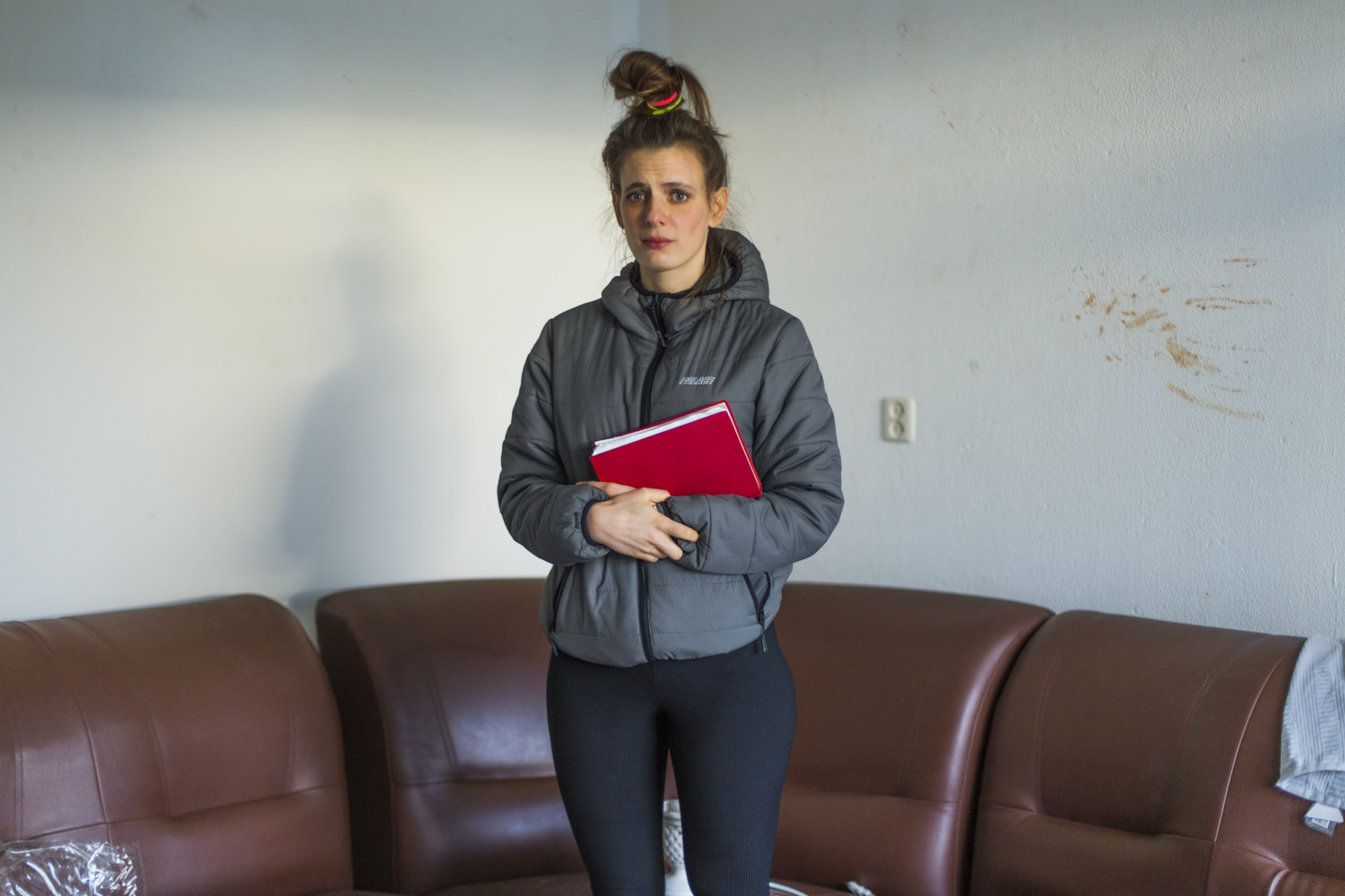vrouw met grijze jas en rood boek