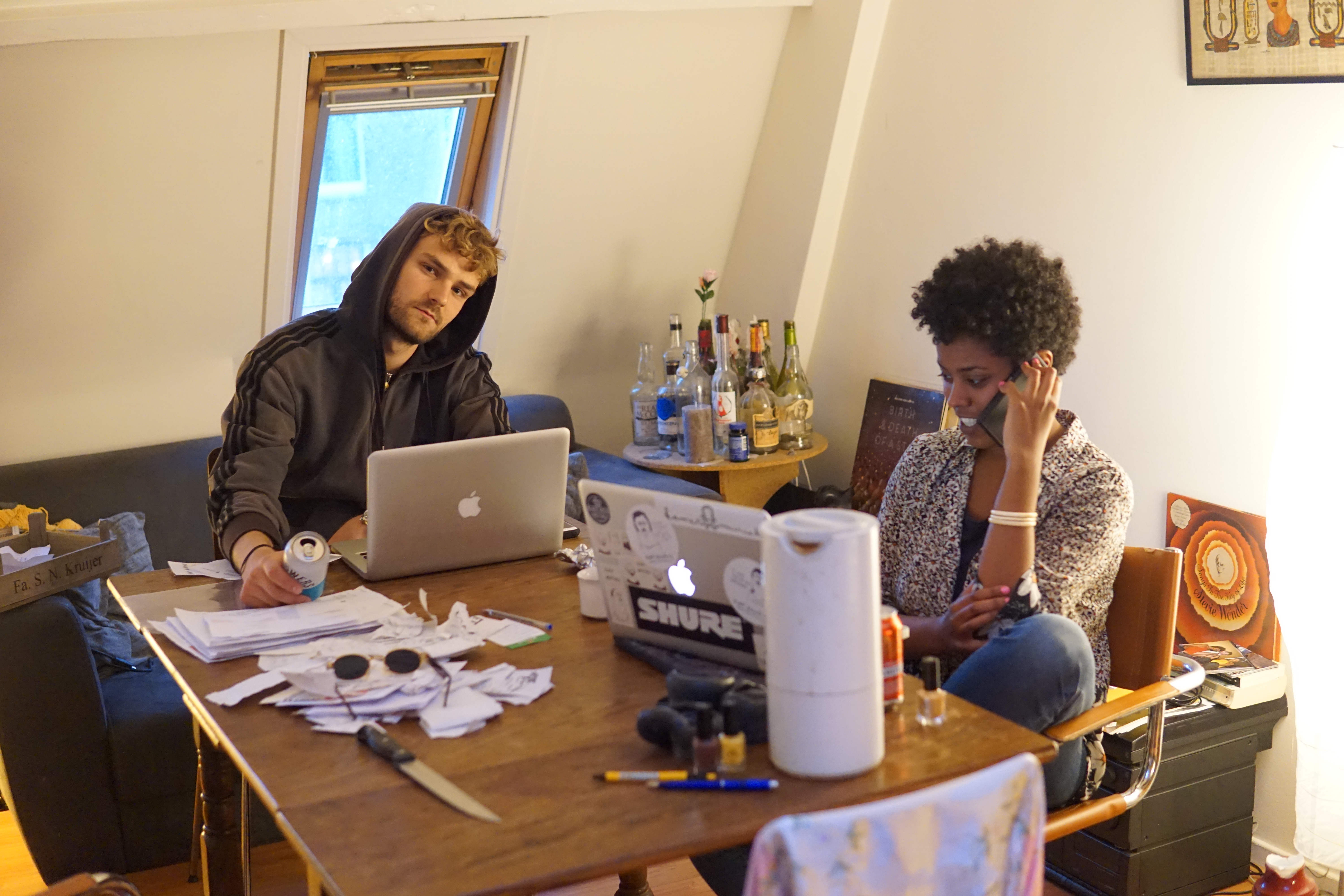 Man en vrouw zitten aan tafel met laptops.