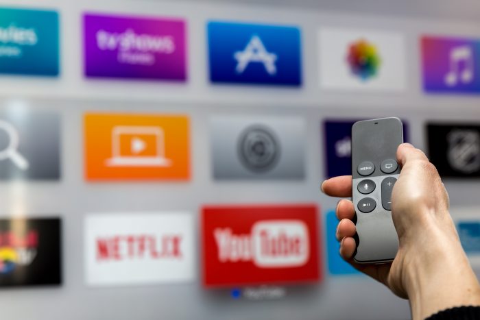 Afstandsbediening en op de achtergrond zie je YouTube, Netflix, etc.