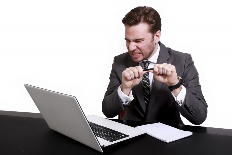 Gefrustreerde man achter laptop