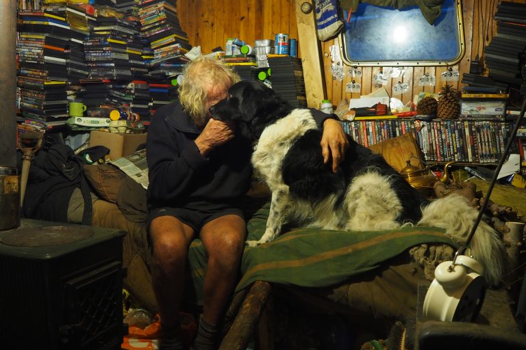 Man knuffelt hond op bed
