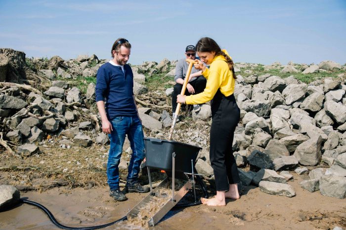 Vrouw schept de natte zand op